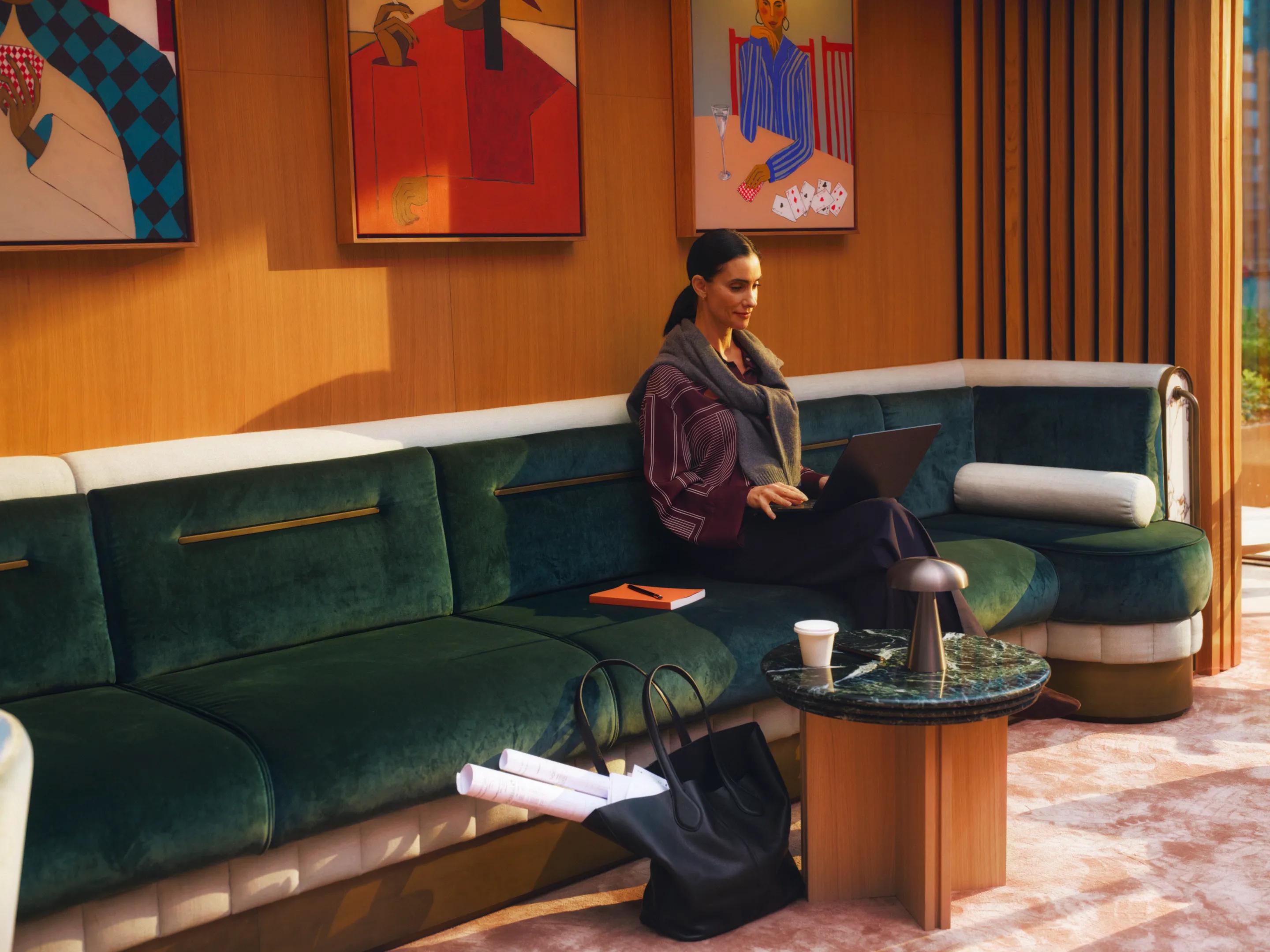 A resident sitting on the curved green sofa in the residents' lounge