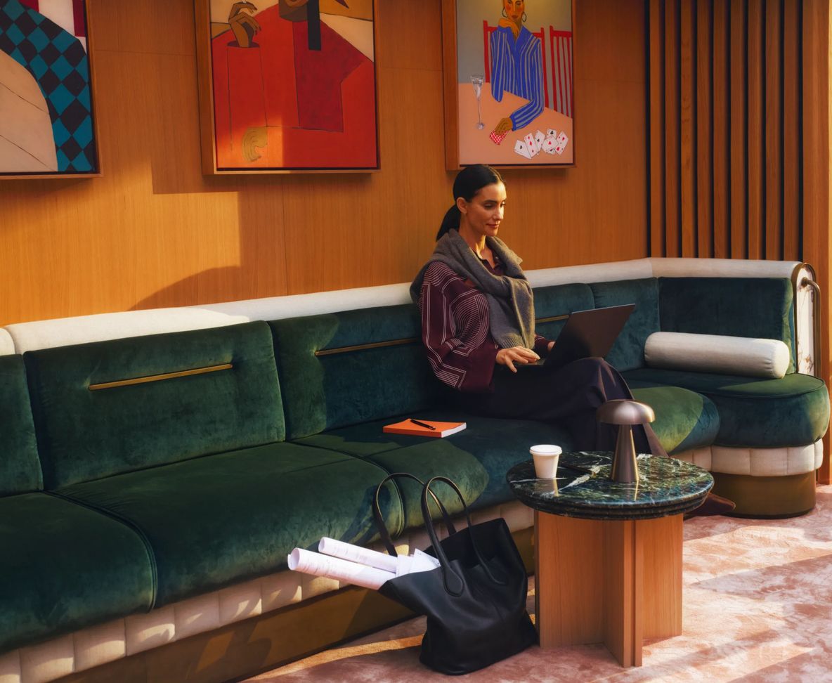 A resident sitting on the curved green sofa in the residents' lounge