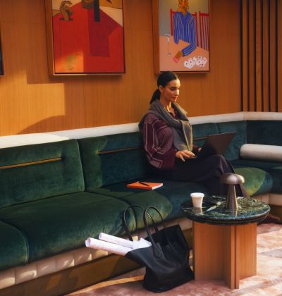 A resident sitting on the curved green sofa in the residents' lounge