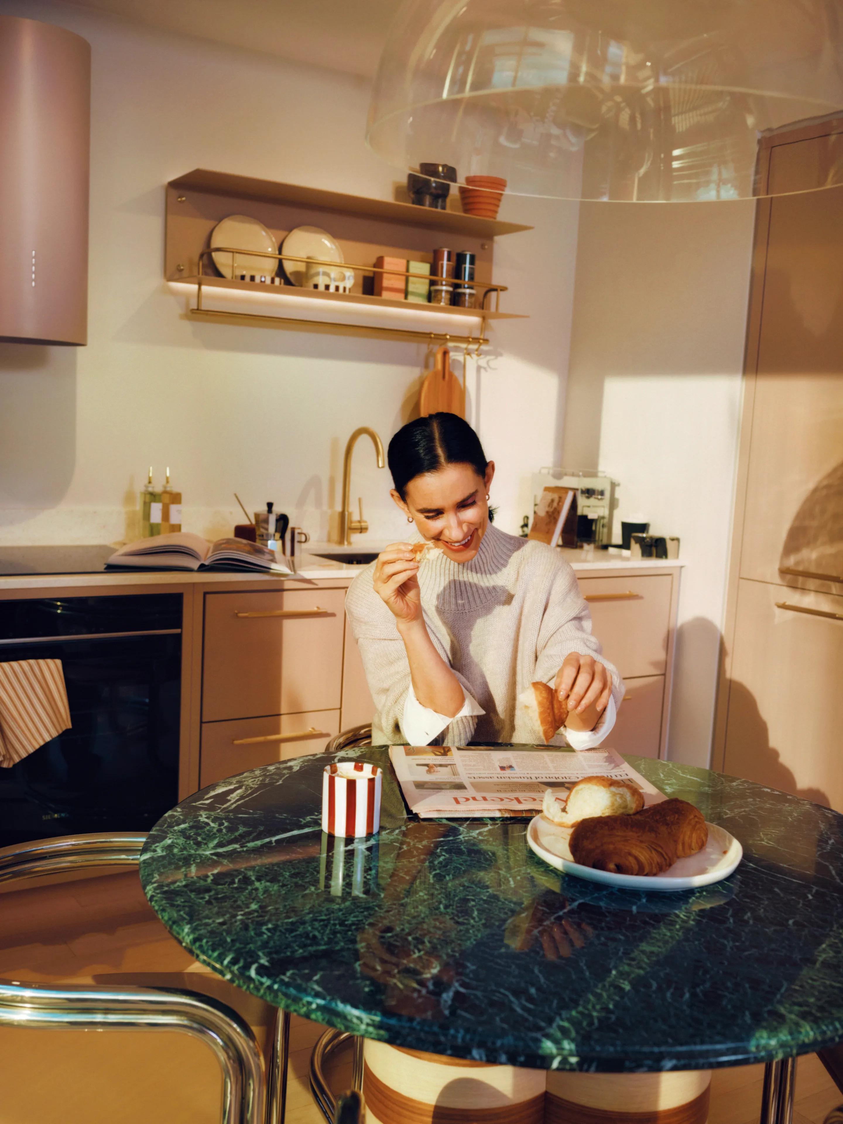 Woman having breakfast at a green marble kitchen island