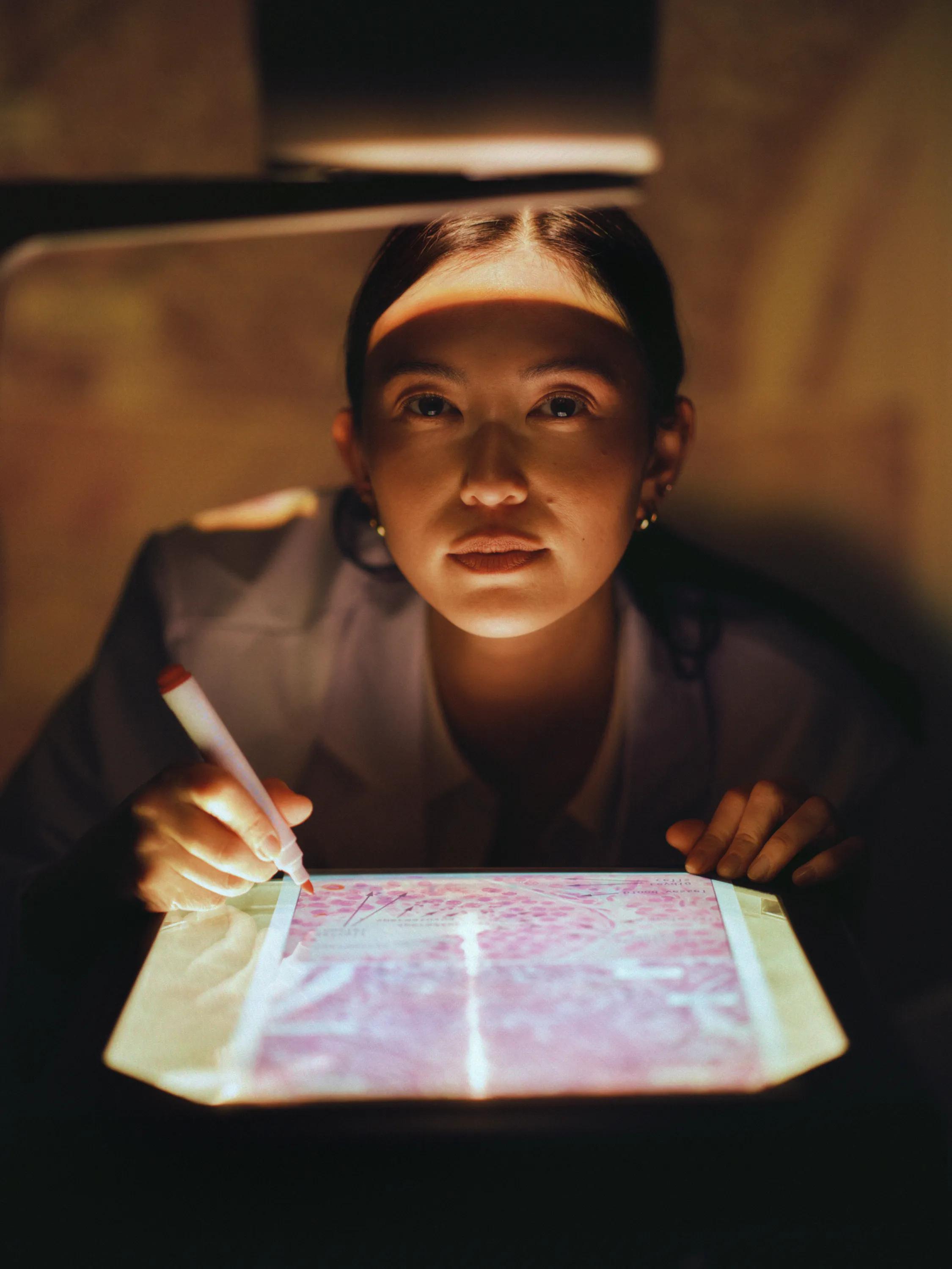 A resident sketching on a backlit tablet in the evening