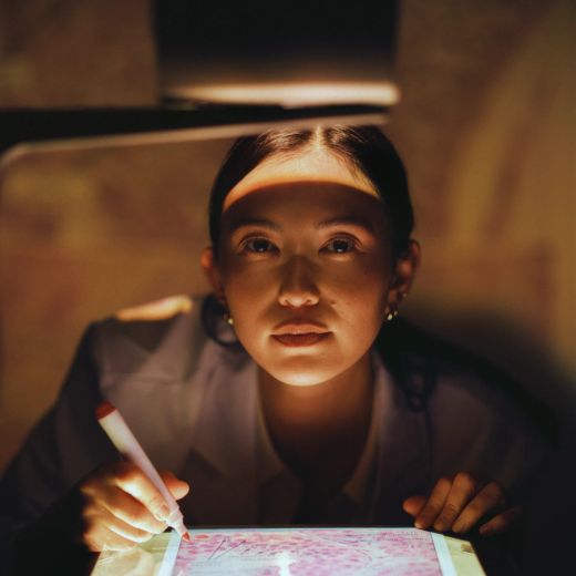 A resident sketching on a backlit tablet in the evening