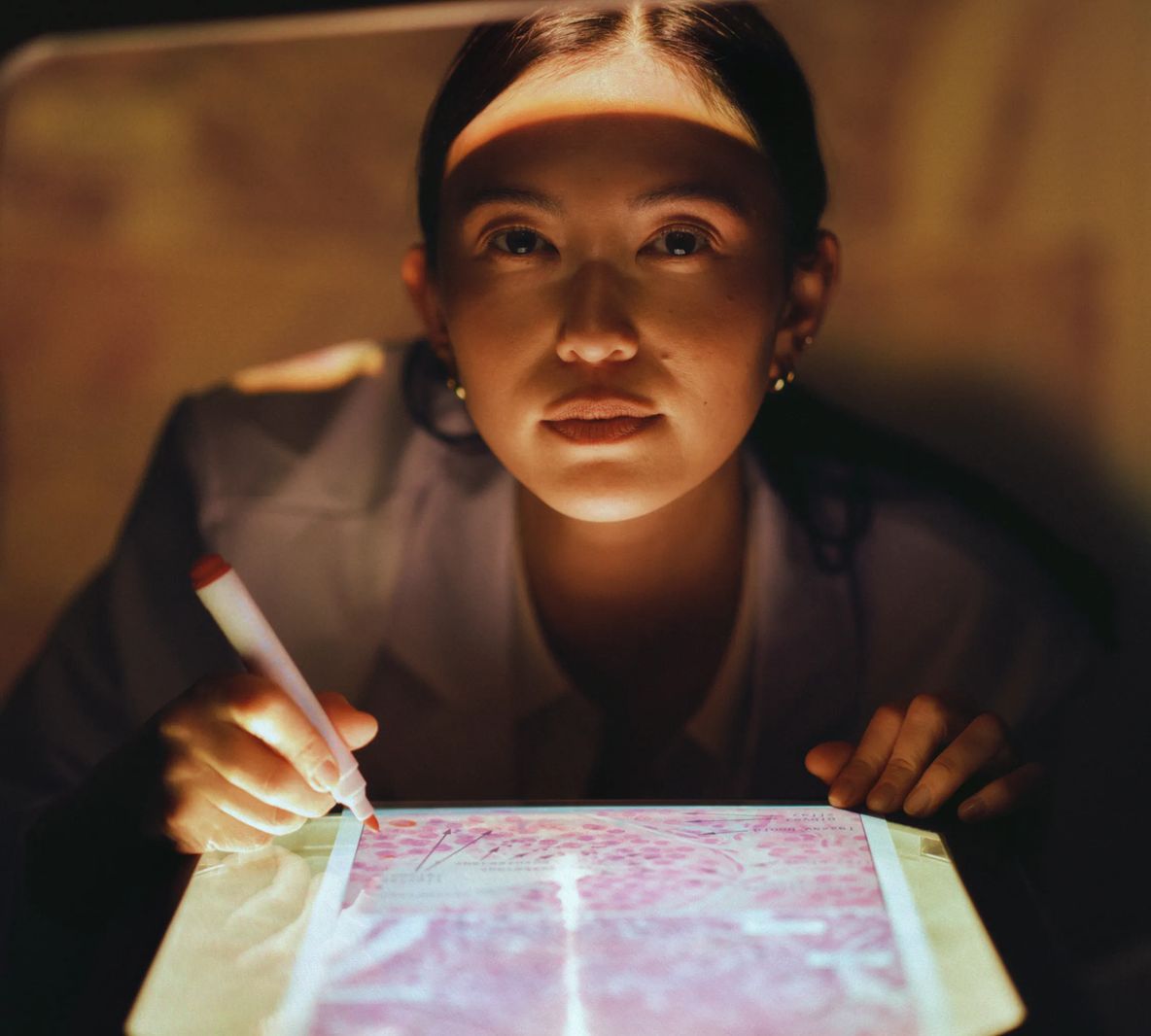 A resident sketching on a backlit tablet in the evening