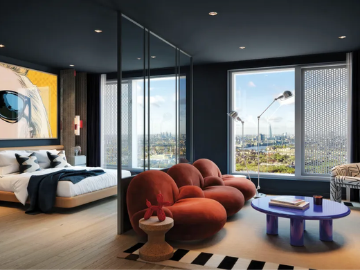 An apartment living room at dusk, a curved sofa framed by floor-to-ceiling windows