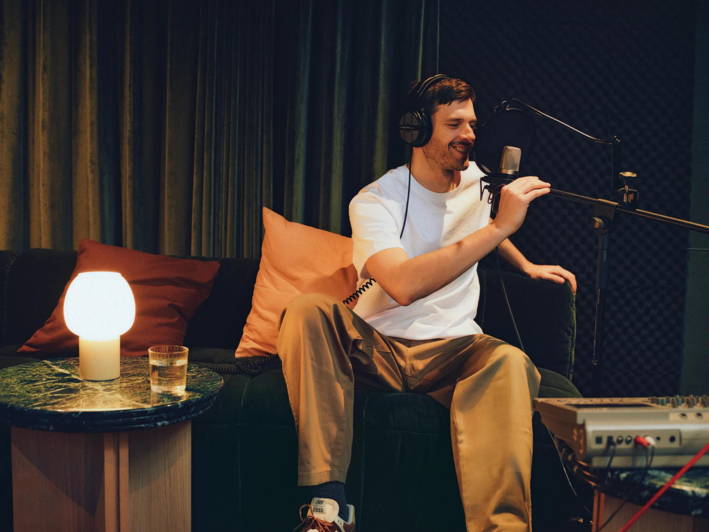 Man recording at a microphone in the residents' studio
