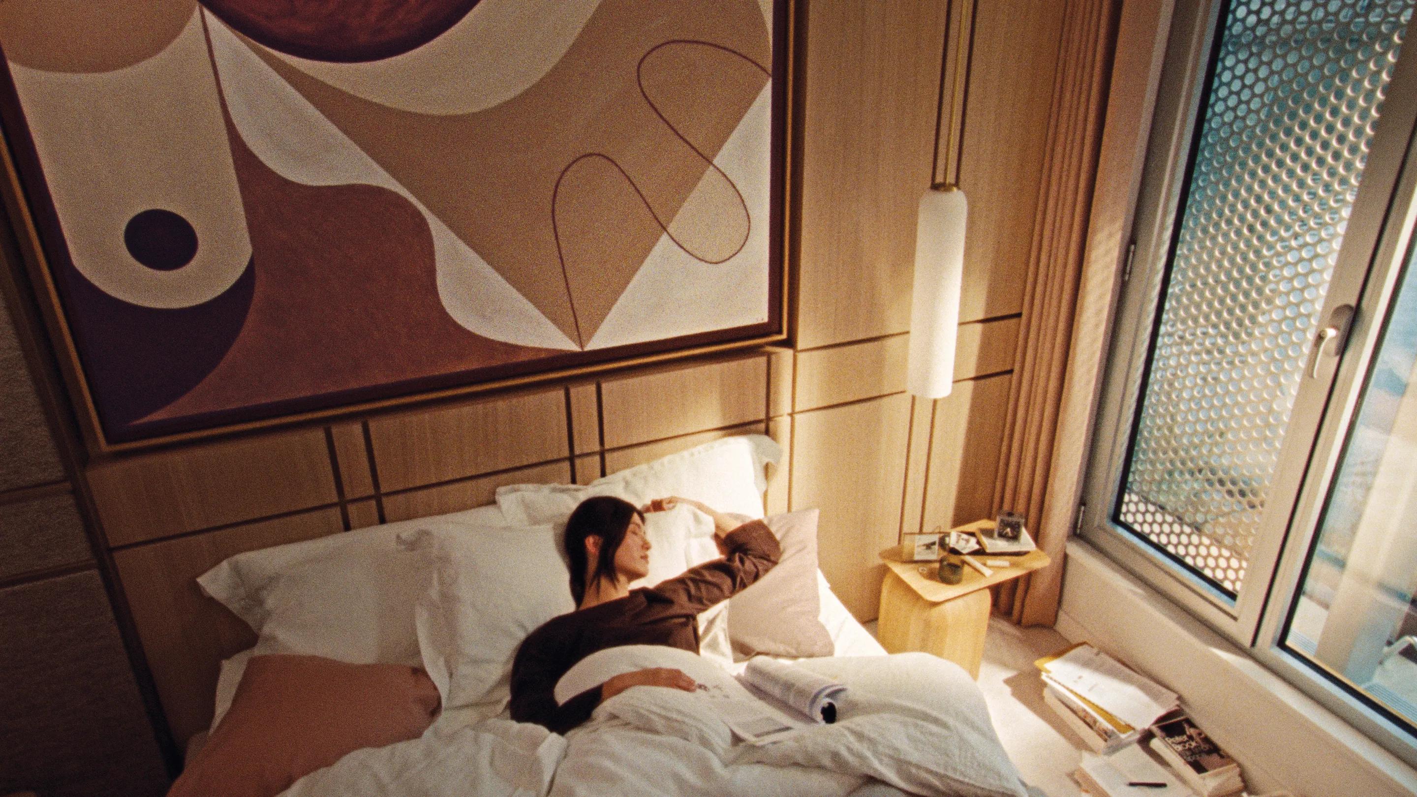 A resident asleep beside a dog, the bedside lamp still lit