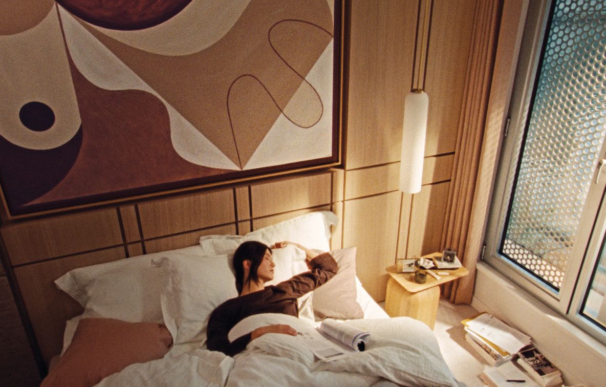 A resident asleep beside a dog, the bedside lamp still lit