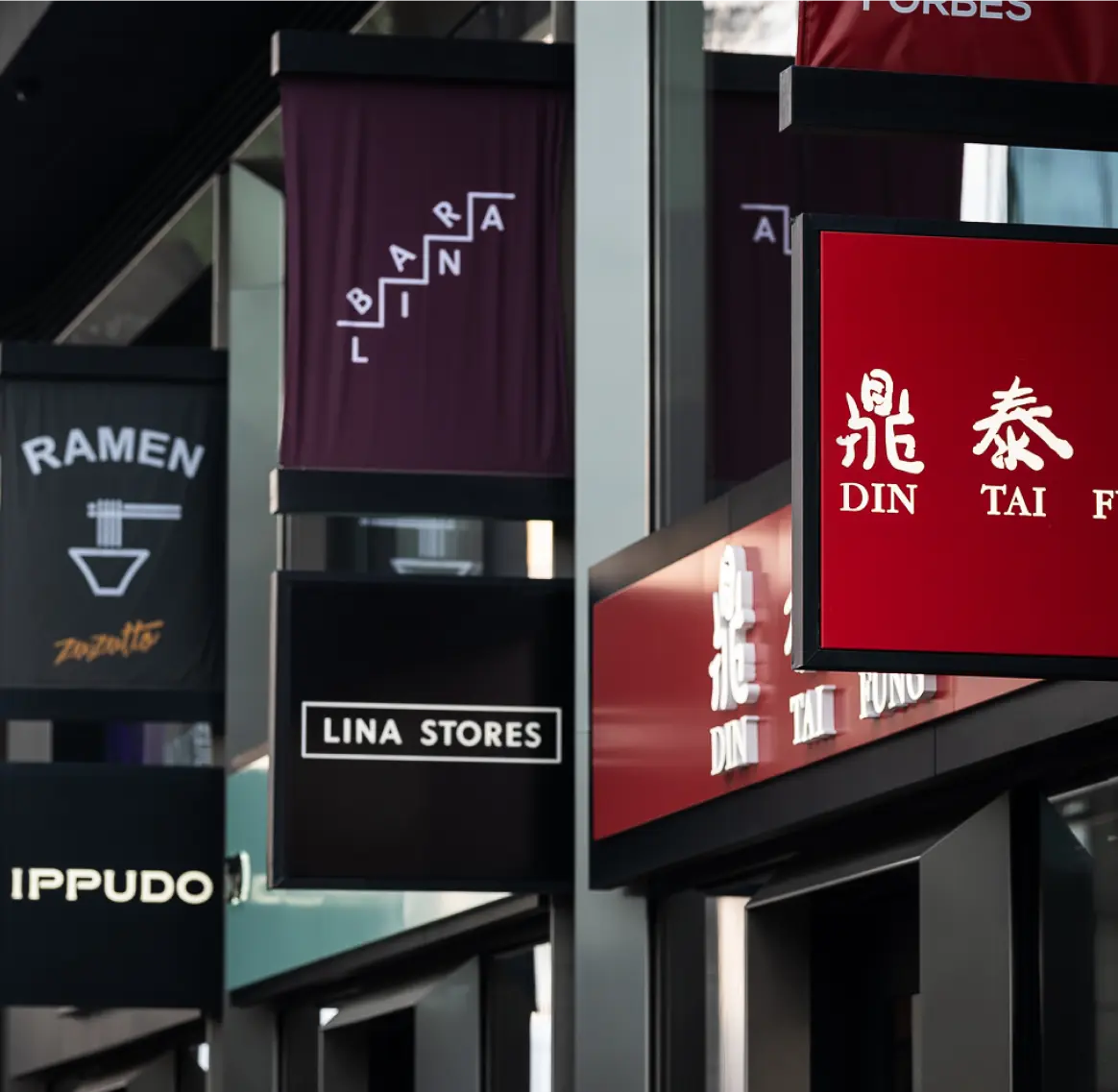 Timber-vaulted shopping arcade with lit restaurant front