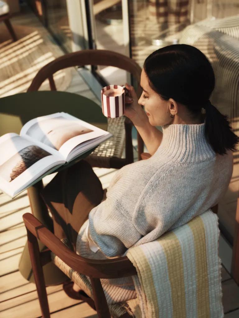 Resident reading a magazine with coffee on the balcony