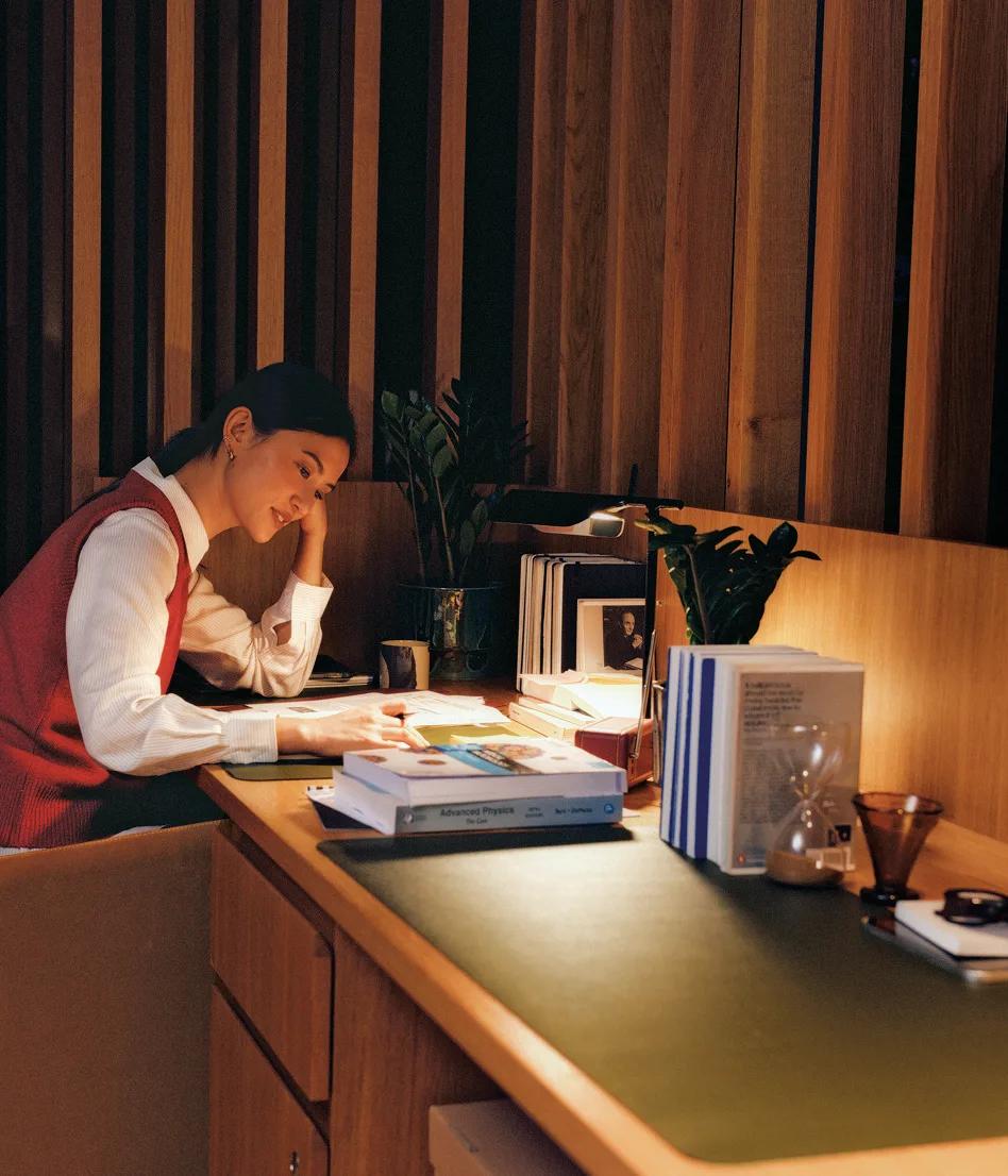 Woman studying at a desk in the wood-panelled Reading Room