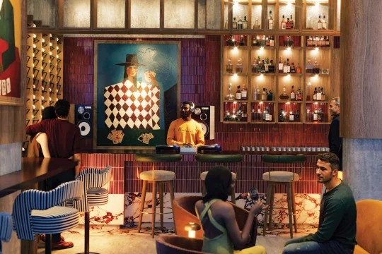 Guests around a warm timber bar with chequered artwork