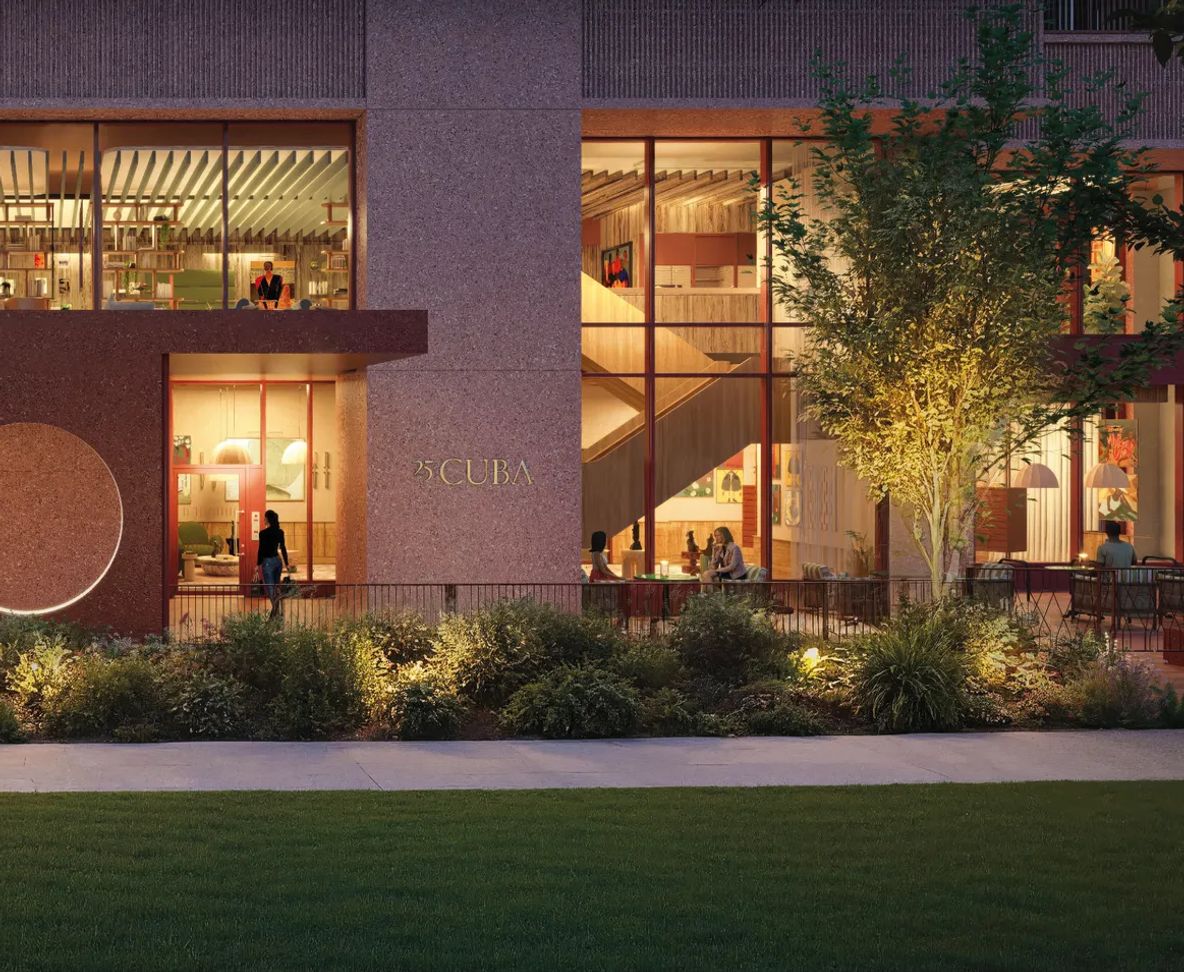 The lit lobby seen from the lawn after dark