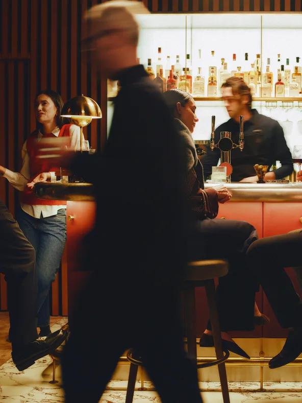 Guests gathered at the marble bar in the evening
