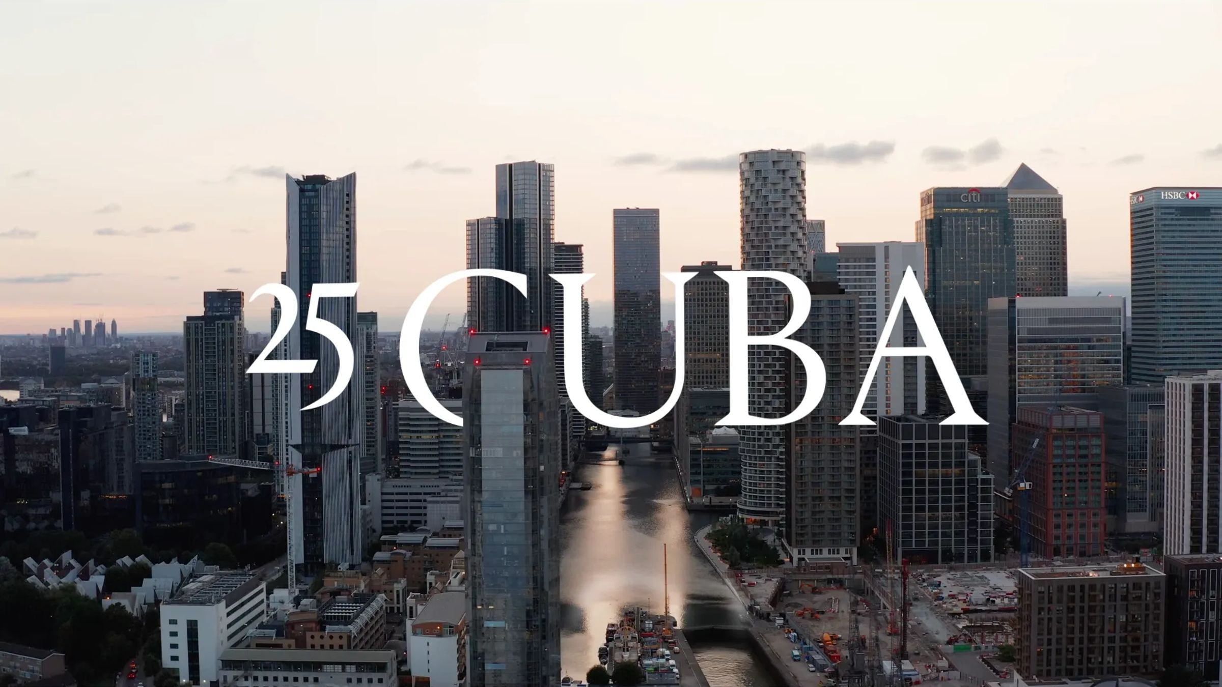 Aerial title frame over the Canary Wharf towers reading 25 Cuba