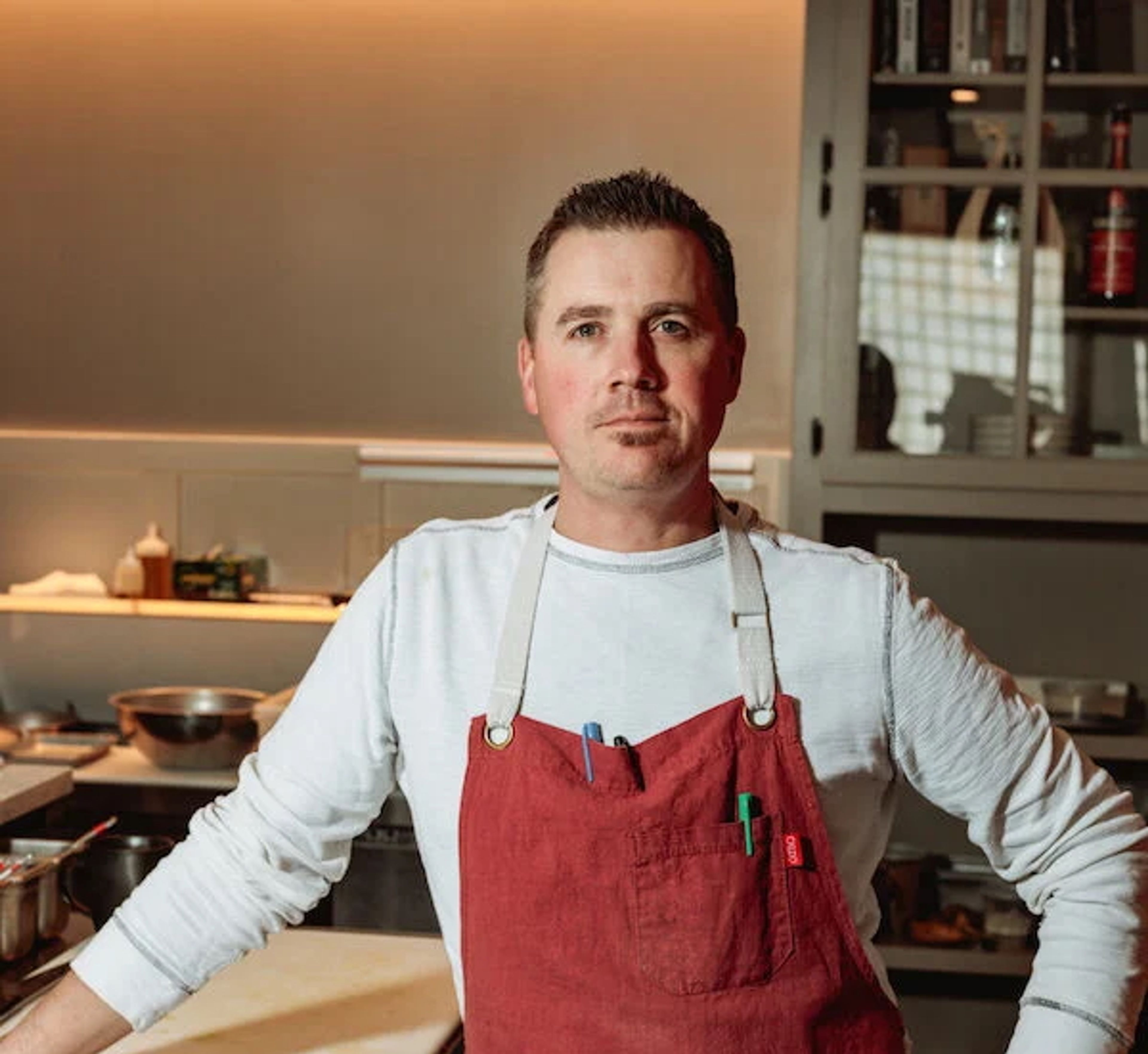Doug Hewitt standing in a red apron