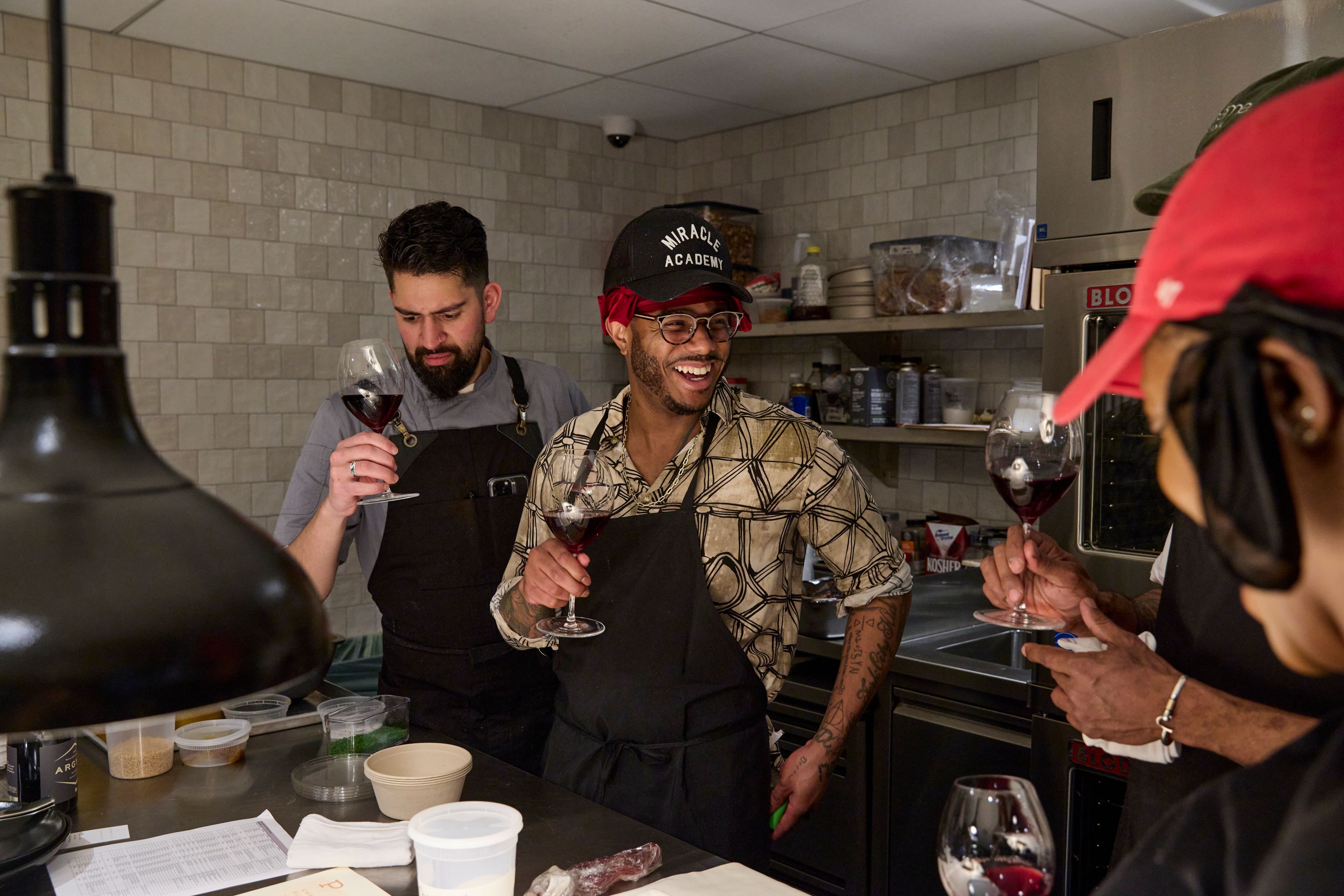 Chefs drinking wine in a restaurant kitchen