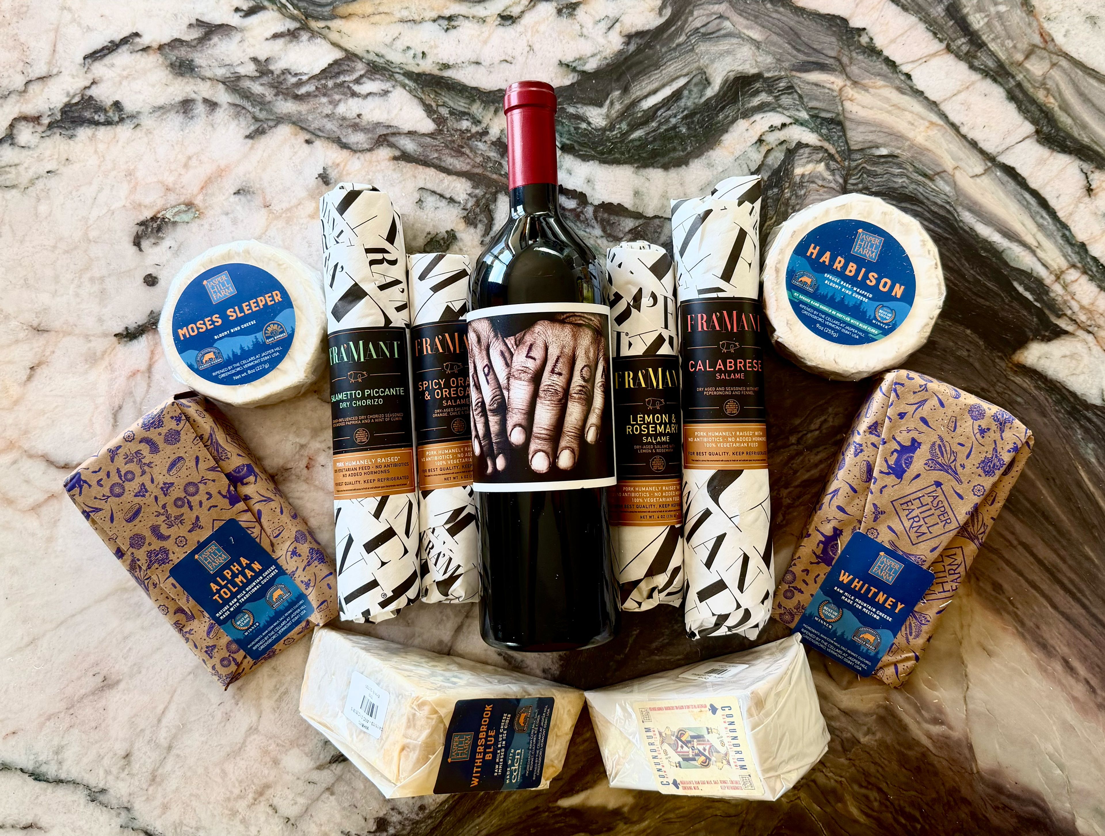 Assorted cheeses and charcuterie with a bottle of wine