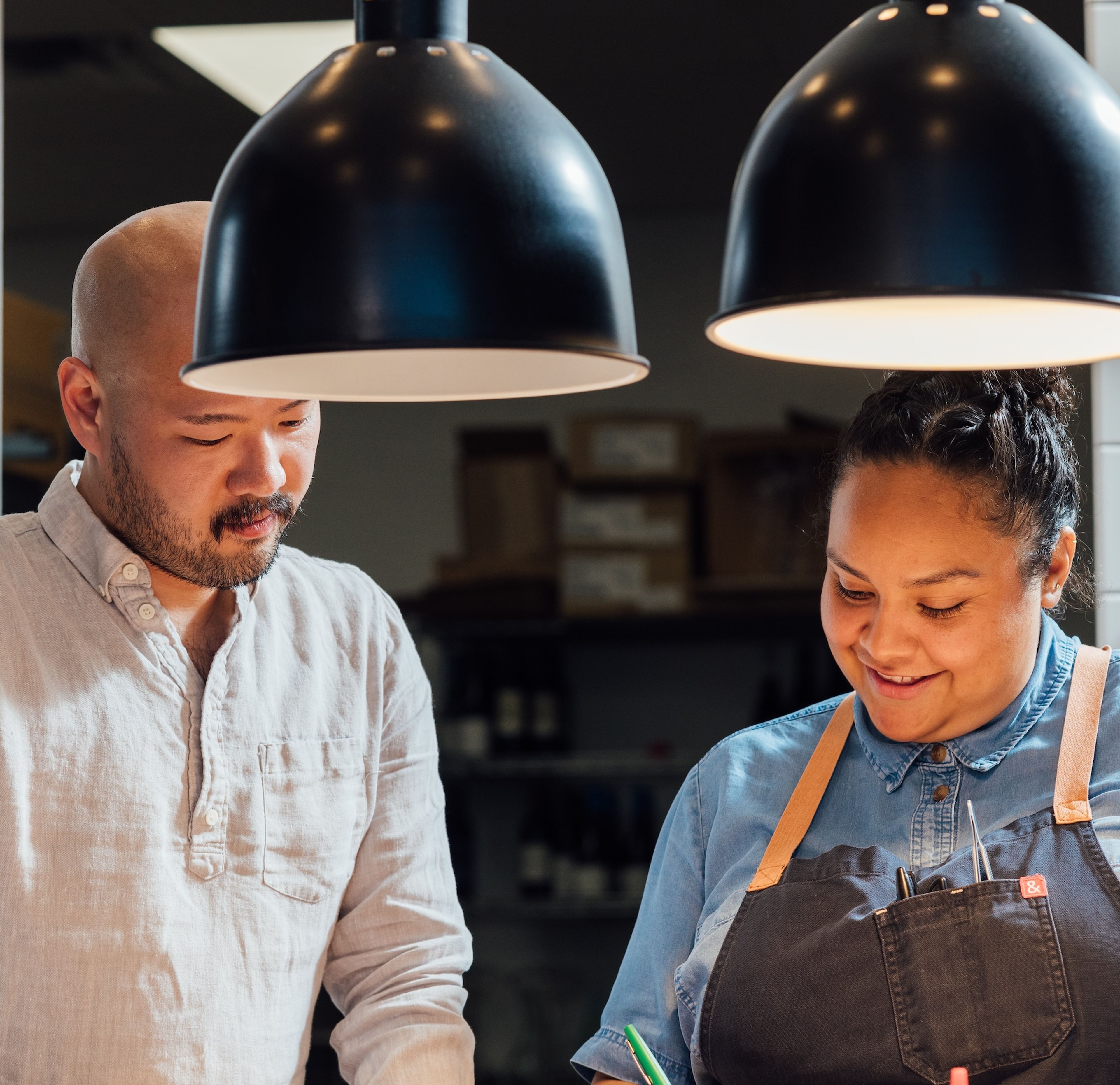 Evelyn Garcia and Henry Lu look at a paper at a kitchen counter