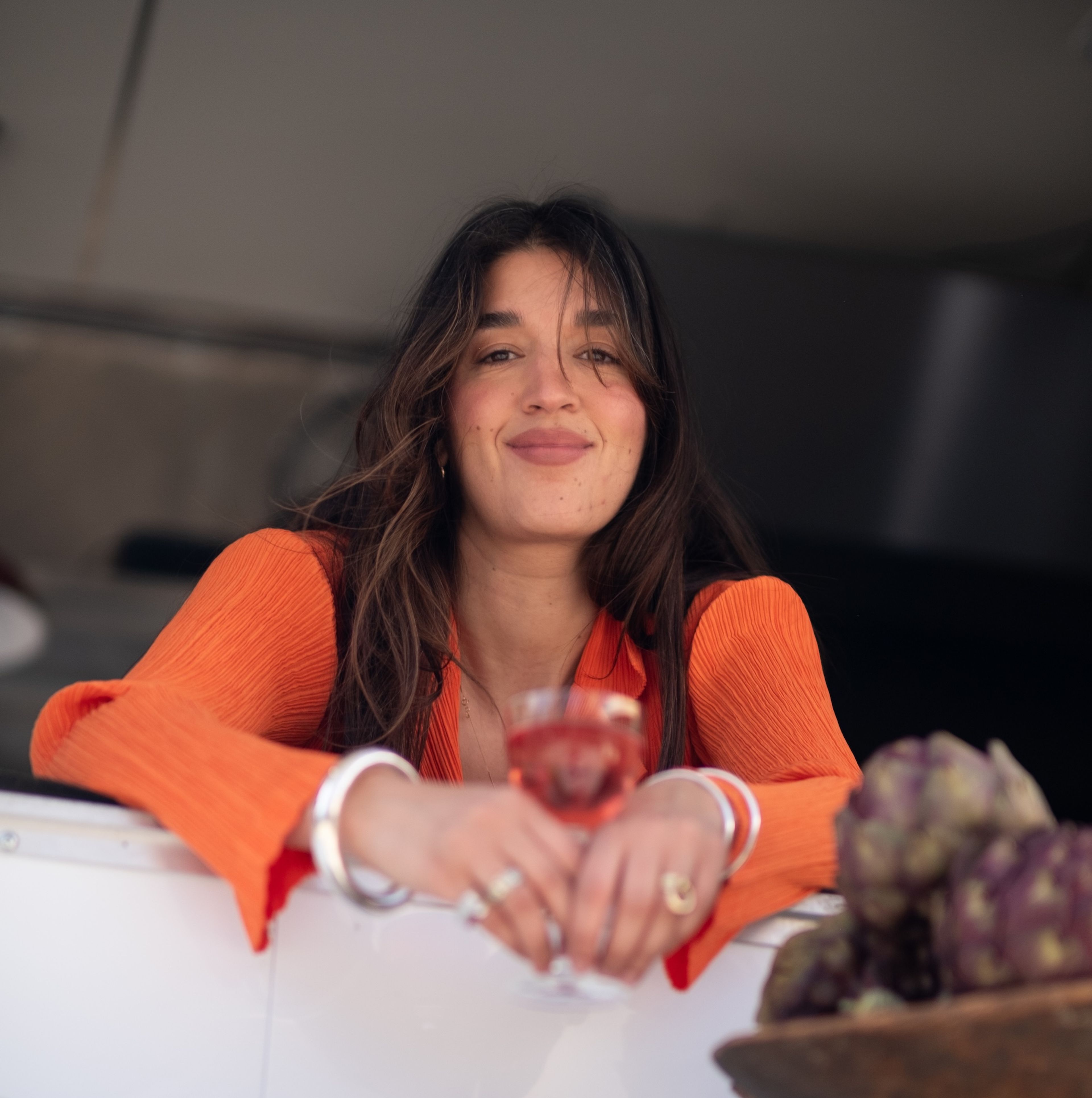 Megan Sanchez looking over a food truck window holding a glass of wine