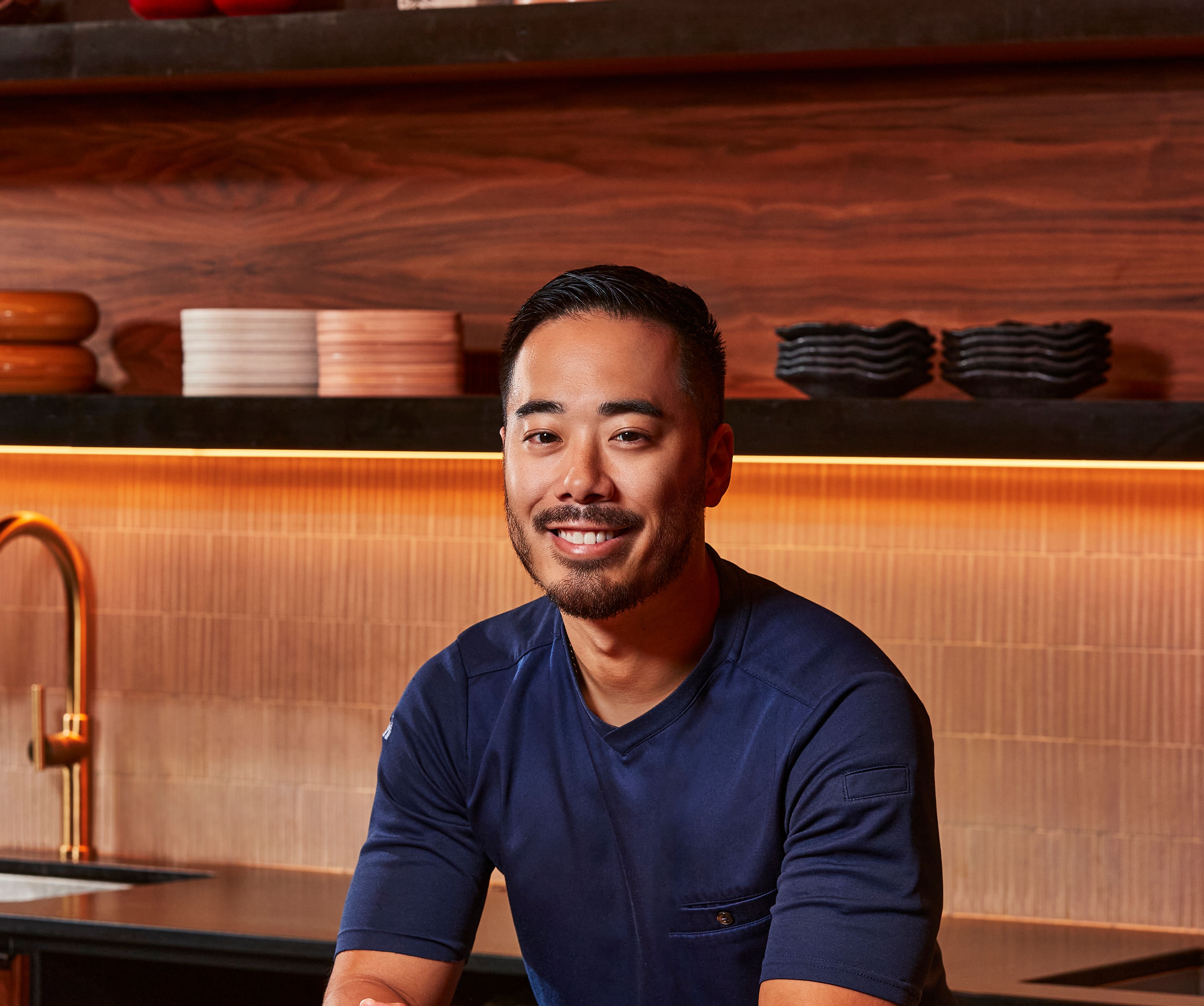 Chef Ito headshot standing in a wood kitchen