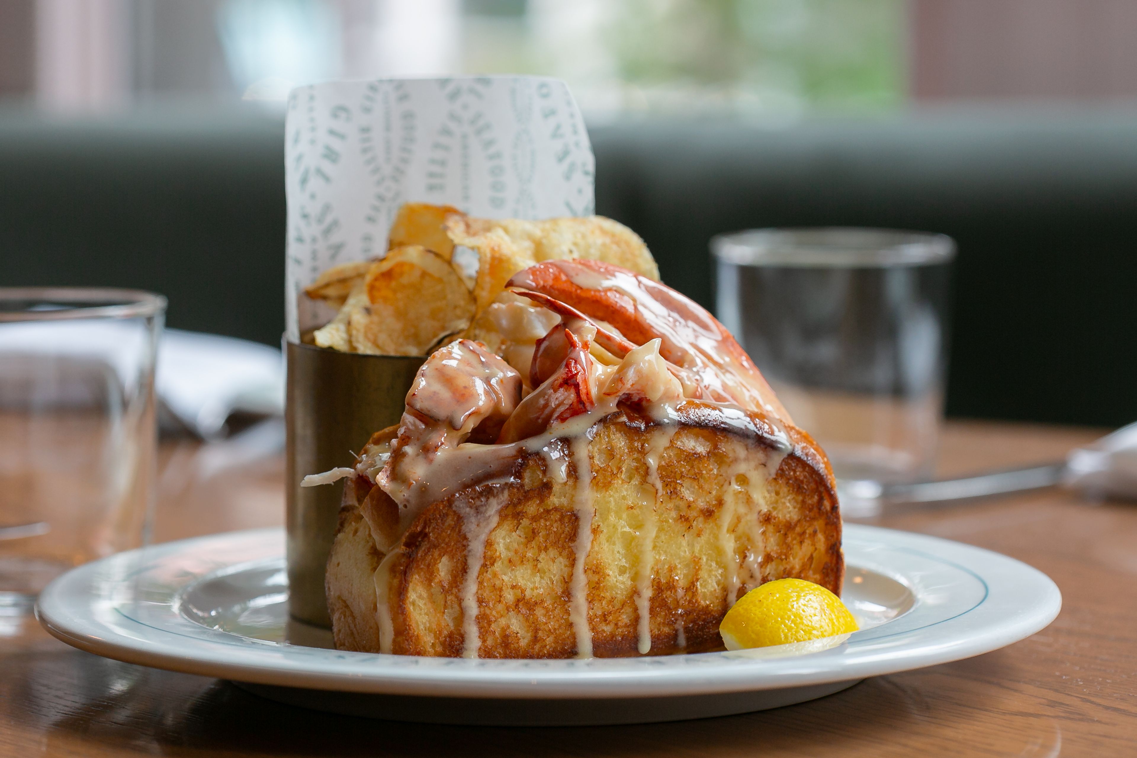 Lobster roll with chips on a plate