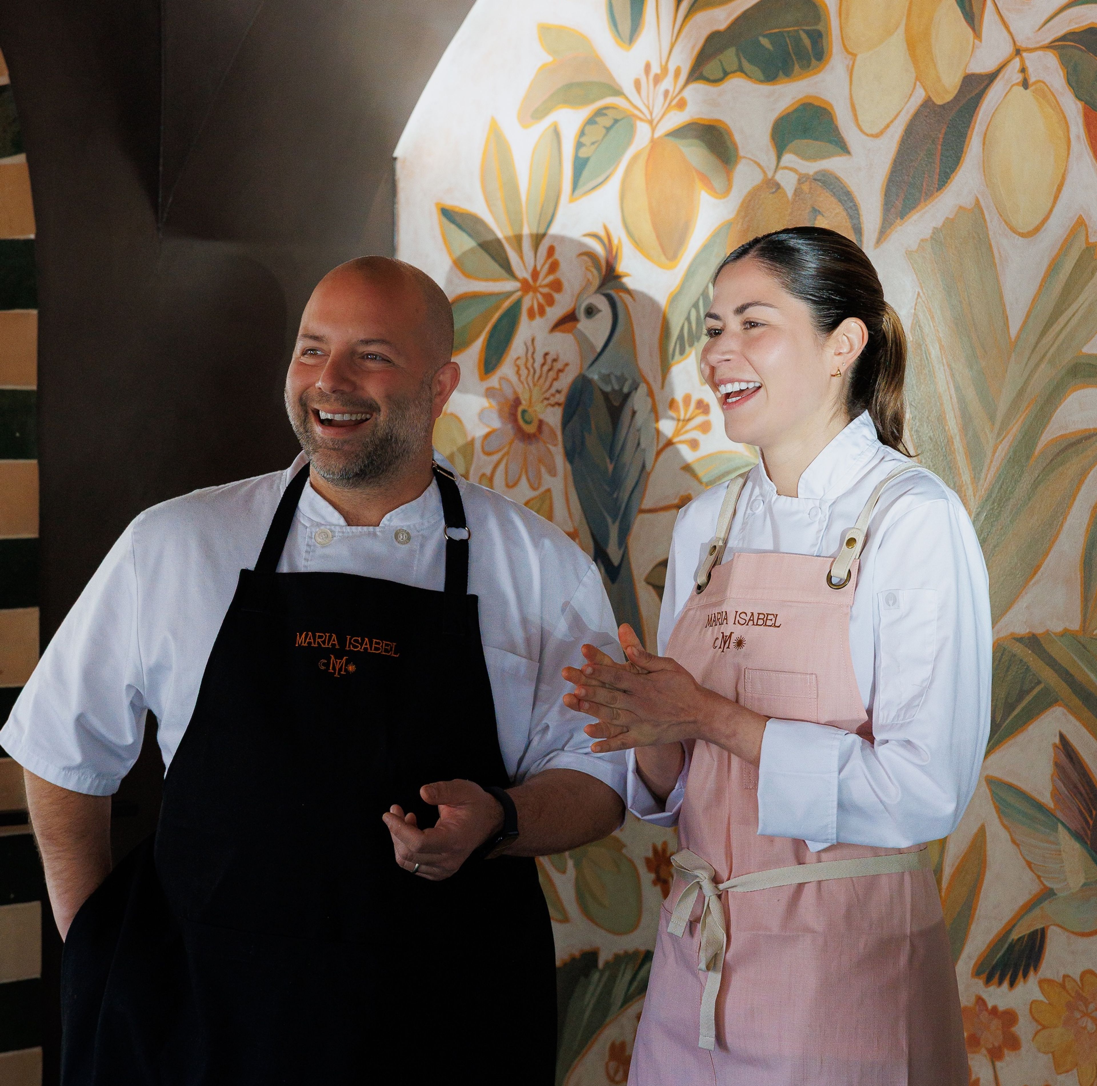Sayat (left) and Laura Ozyilmaz smiling in chef uniforms