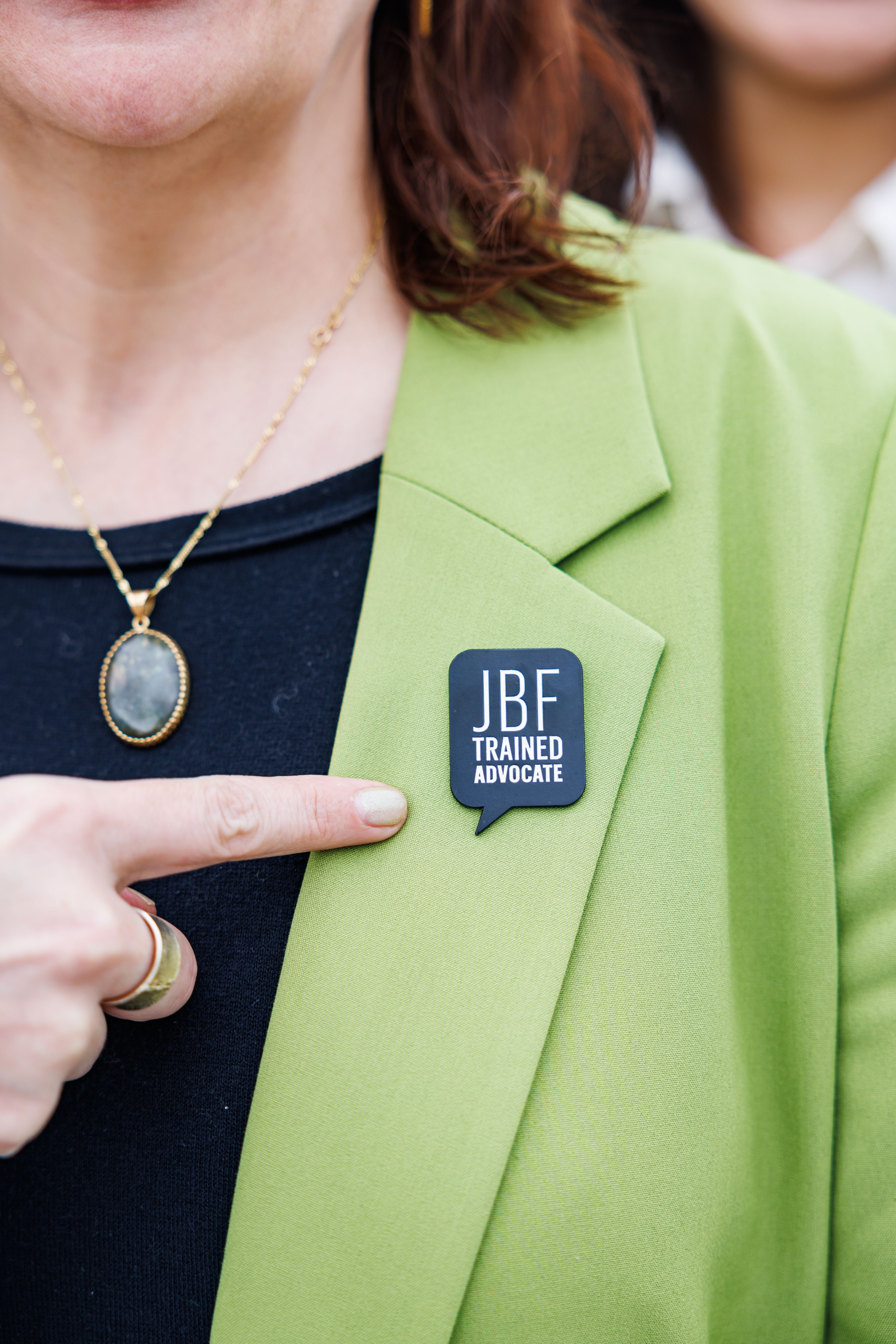 Anne McBride points to a pin on her lapel that says "JBF Trained Advocate" (Photo: Noh Leftovers/JBF)