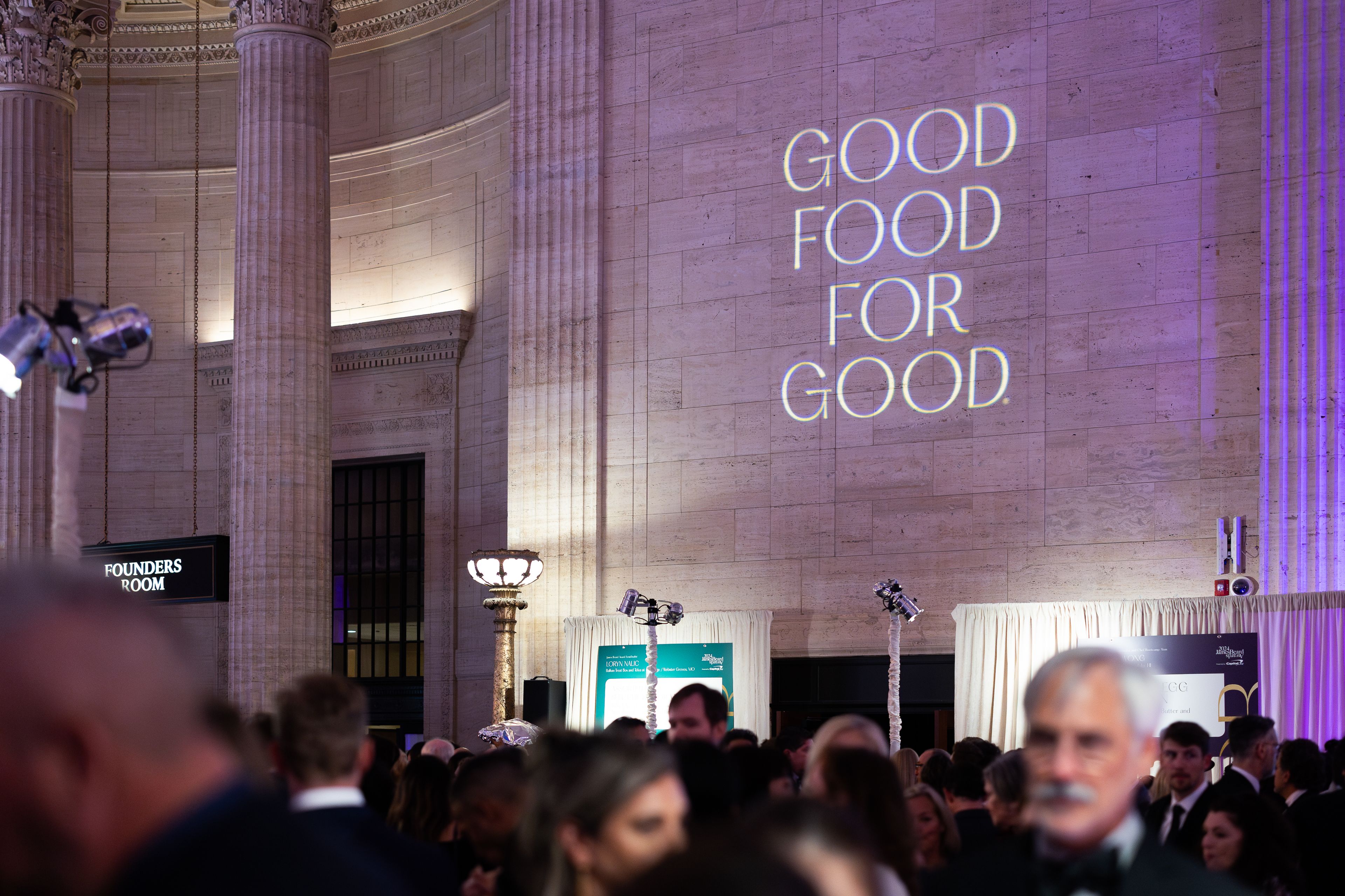 The reception hall for the 2024 James Beard Awards, with "Good Food for Good" projected on the wall
