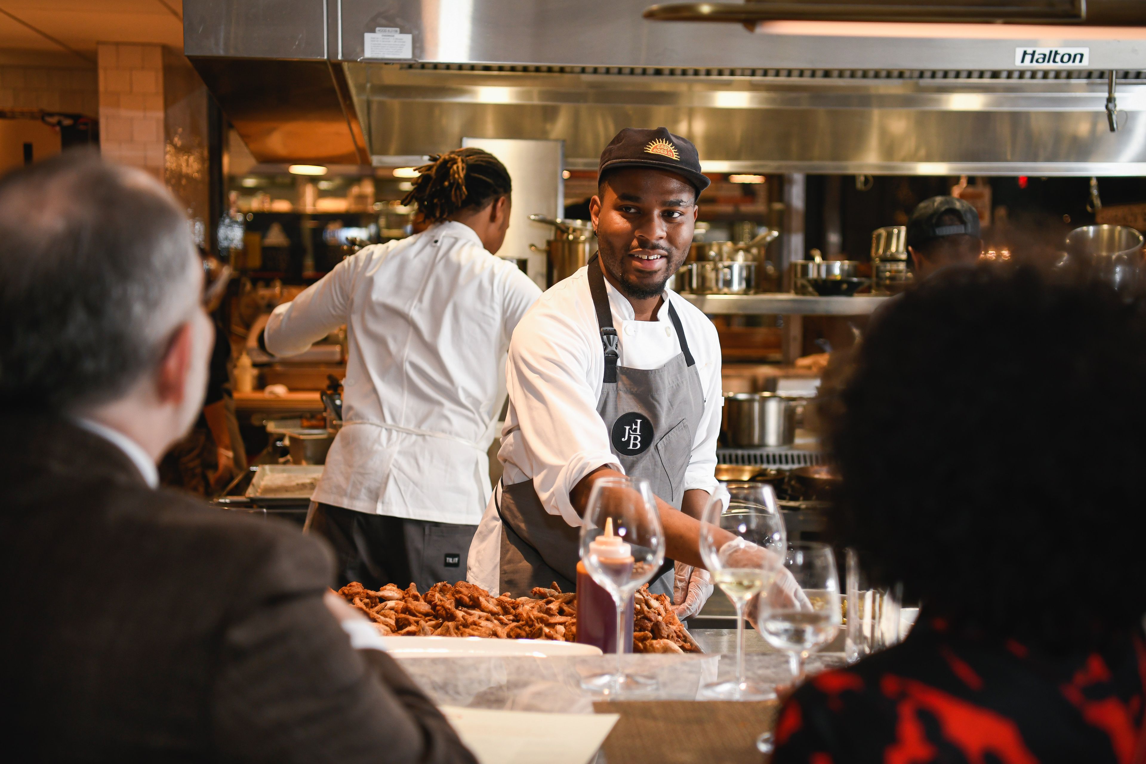 Chef in the kitchen talking to diners