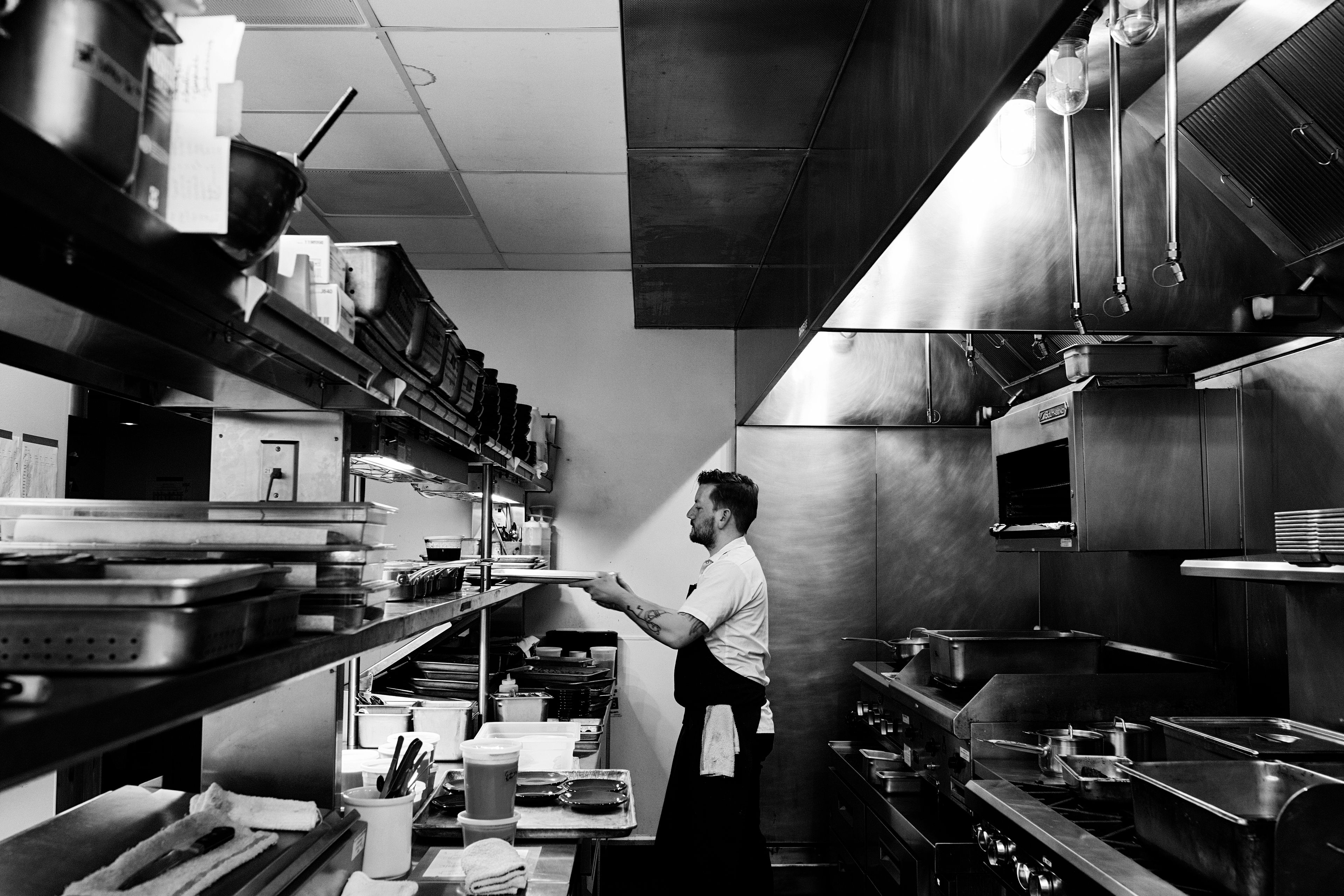 Chef in black apron in a restaurant kitchen