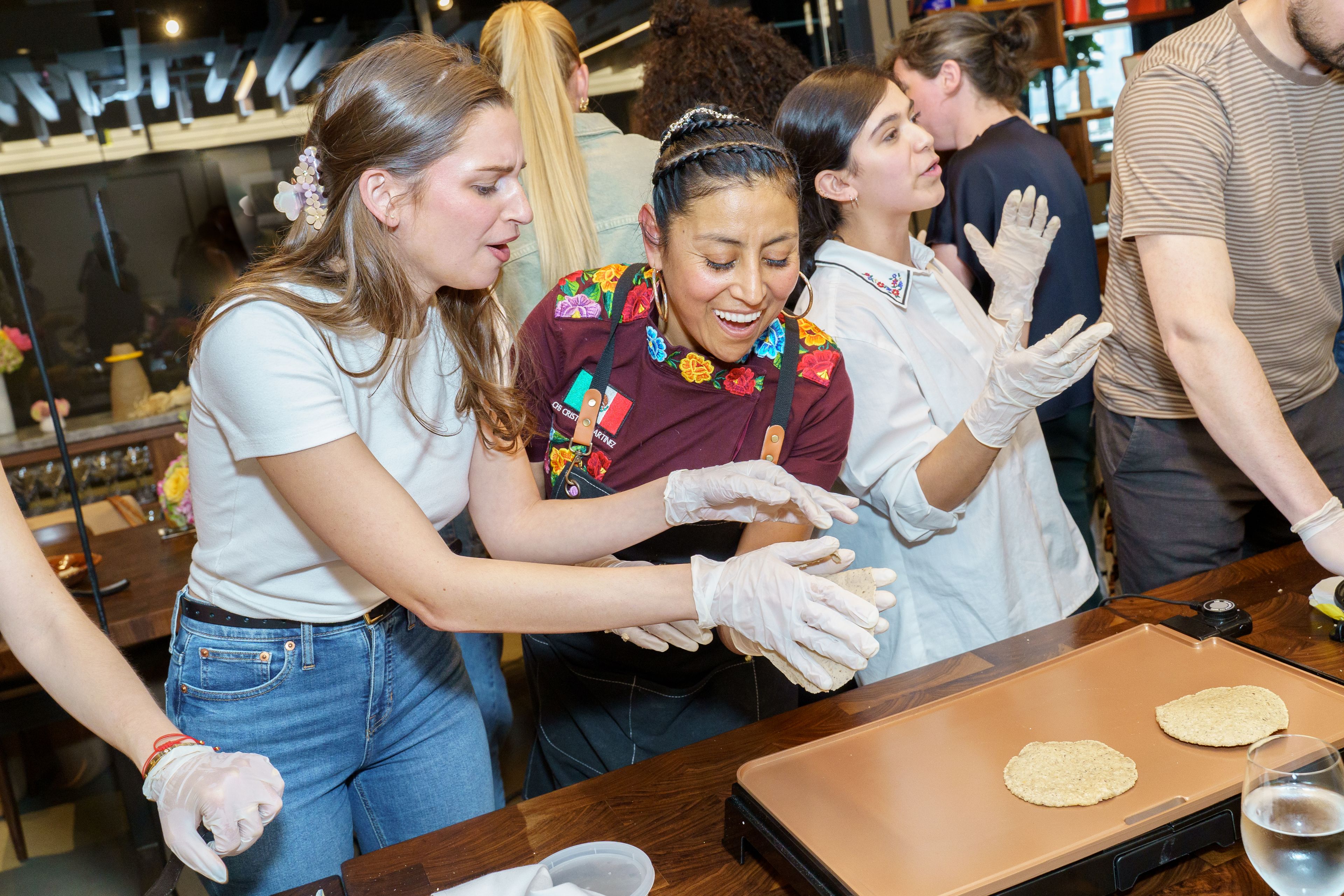 Chef teaching a woman to make tortillas