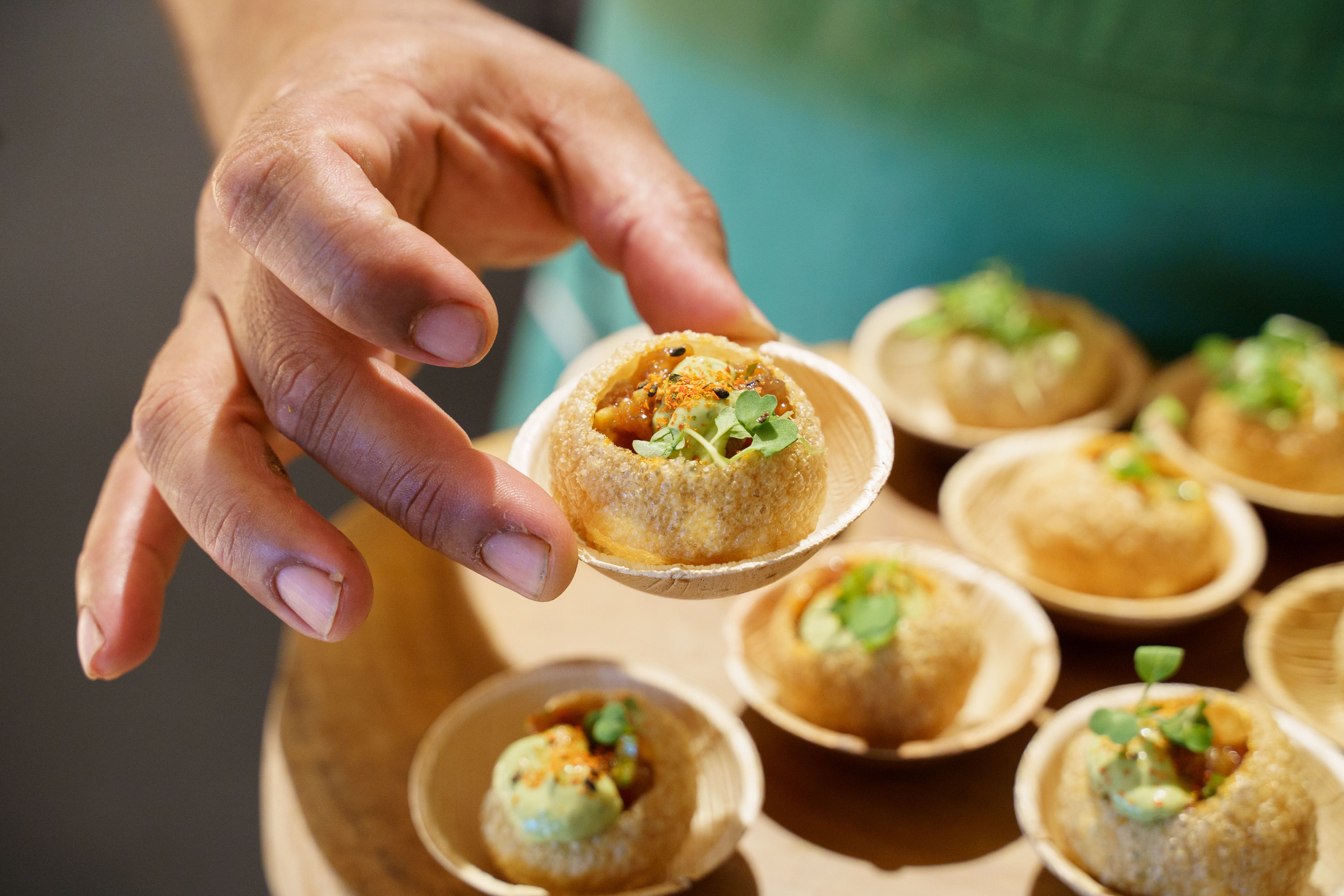 Pani puri being offered on a small plate