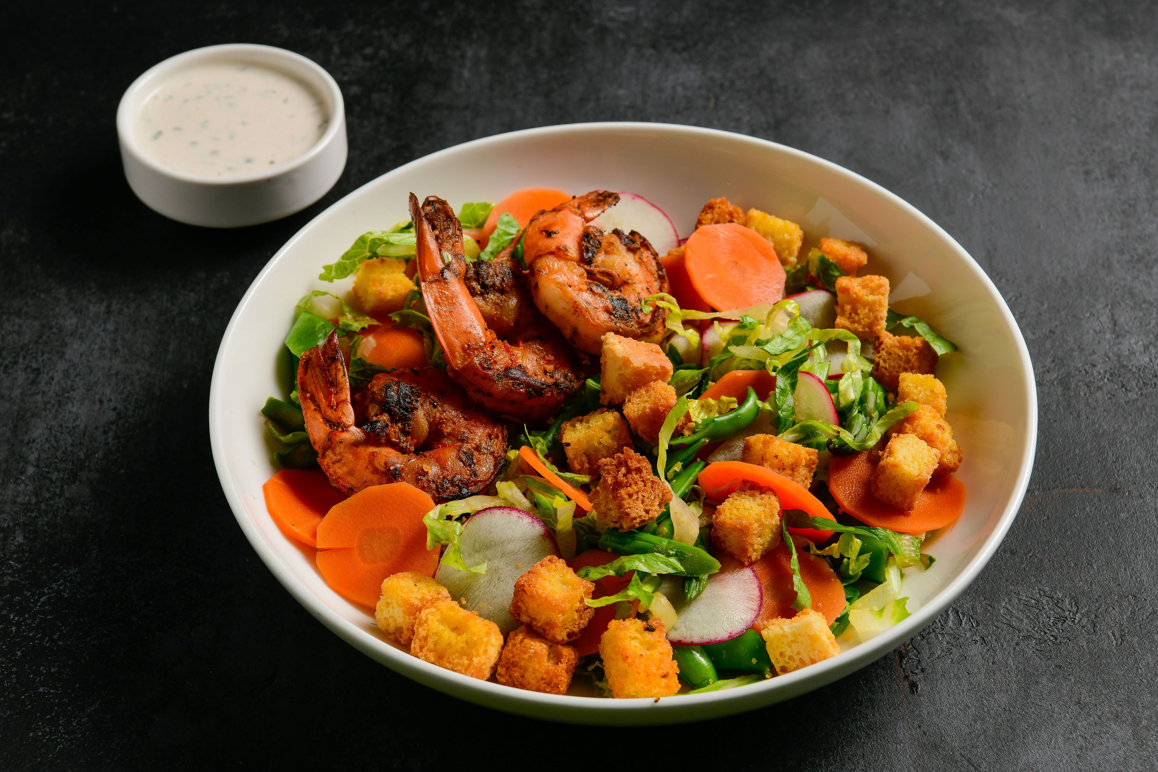 Shrimp and greens in a white bowl