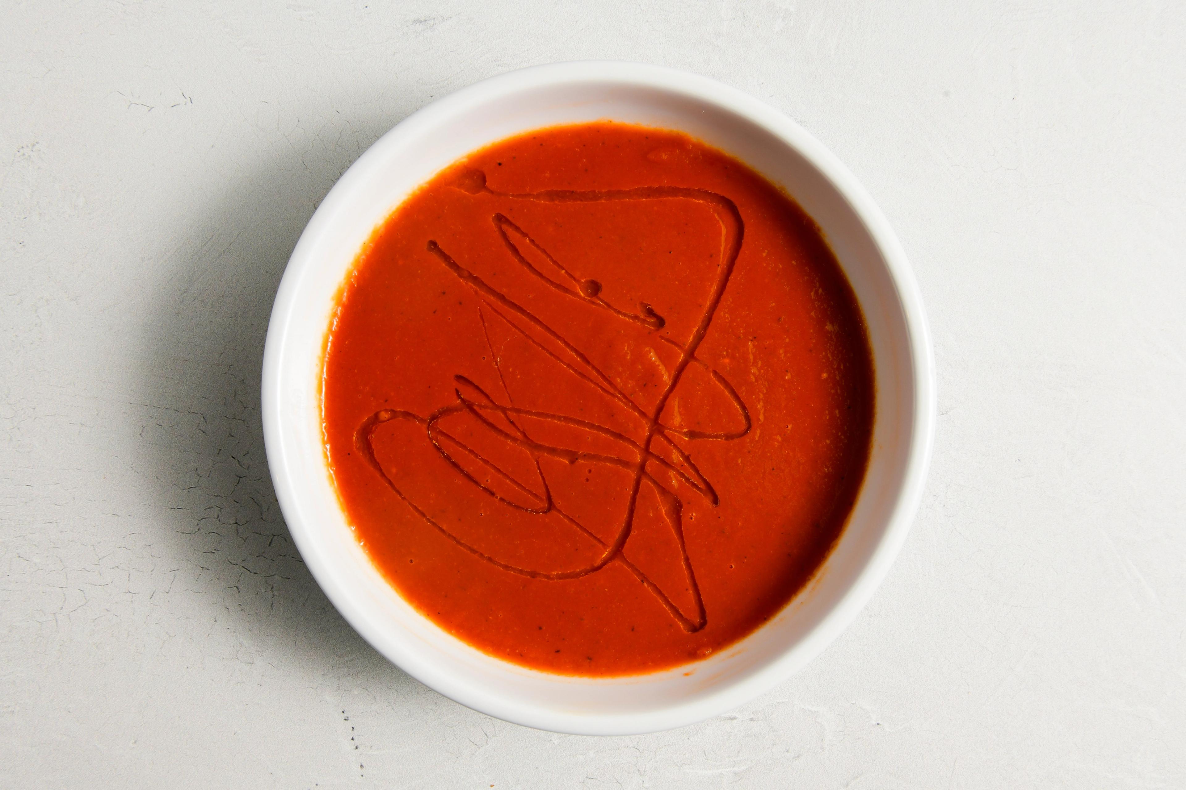 A bowl of tomato soup with olive oil drizzle