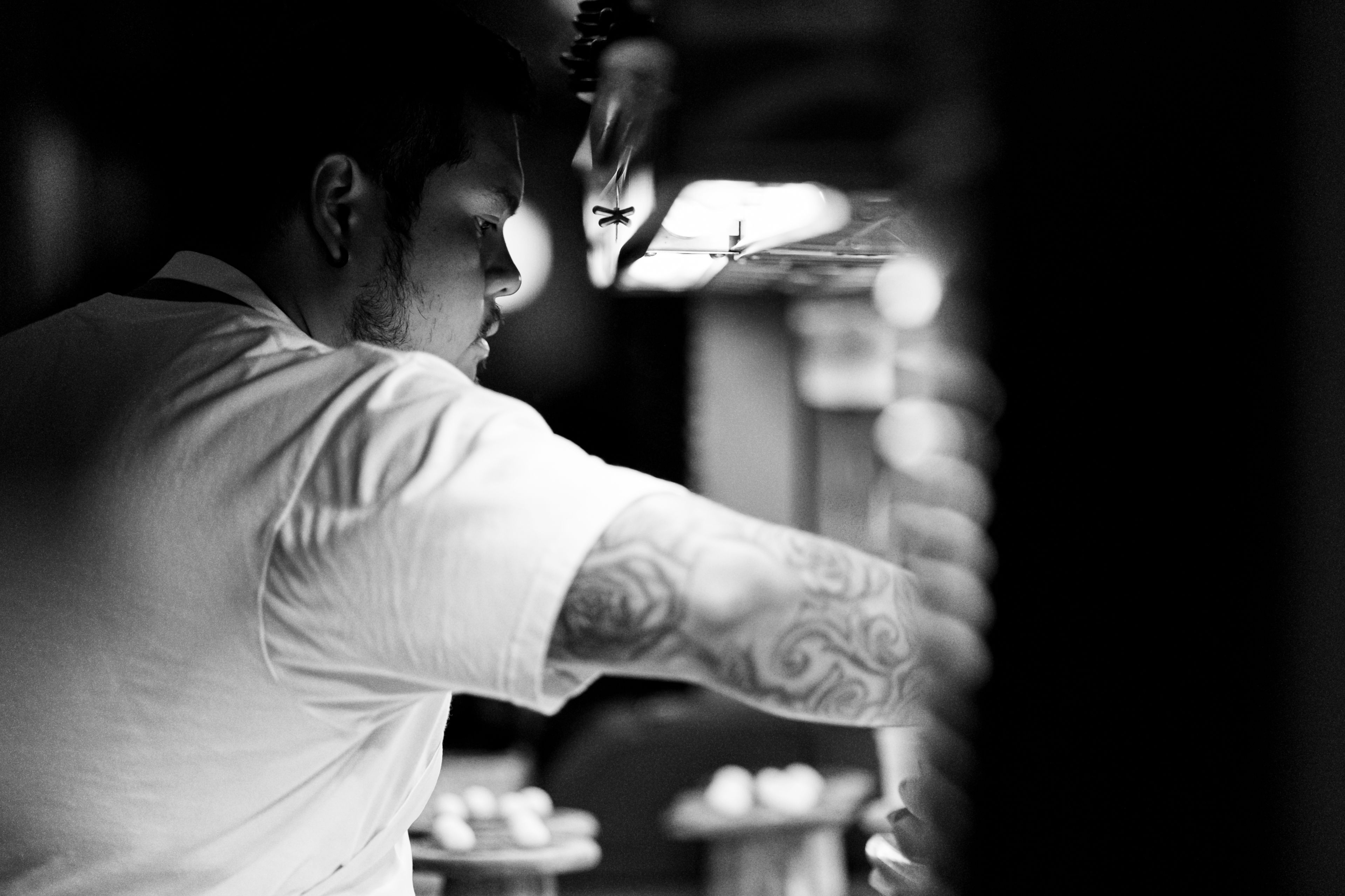 Chef reaching to plate in kitchen