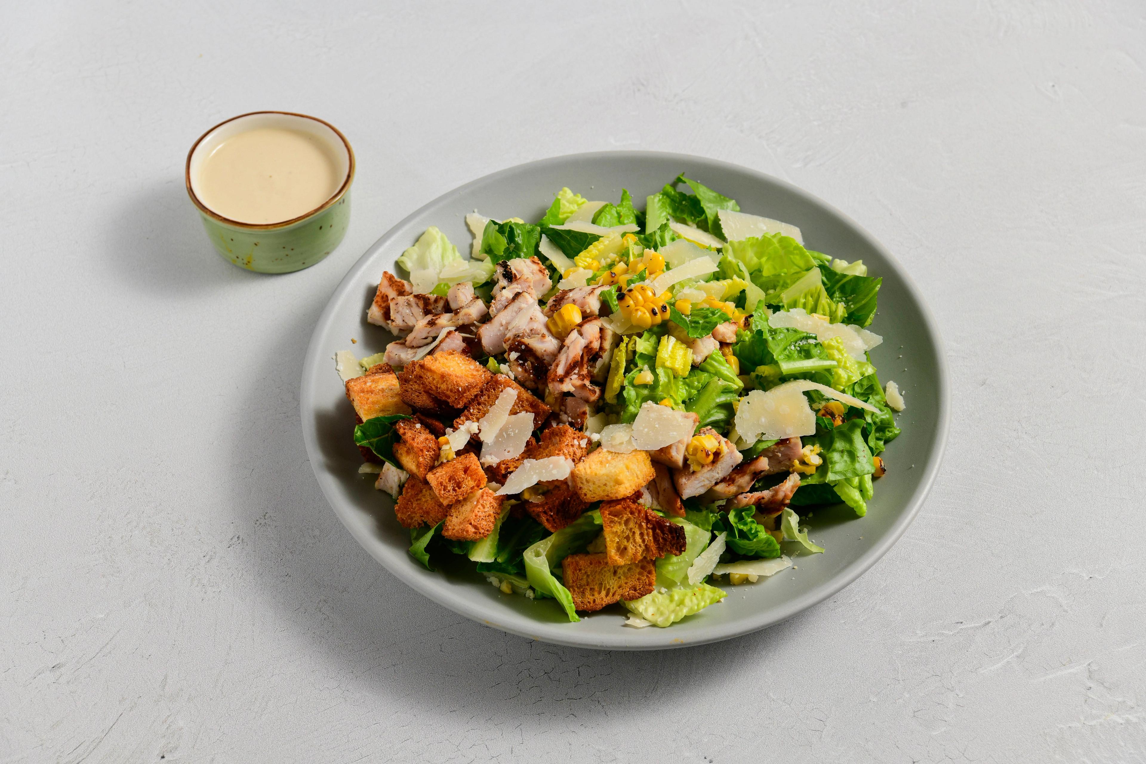 Grilled Caesar Salad with Charred Corn, Parmesan, and Sourdough Croutons and dressing on the side