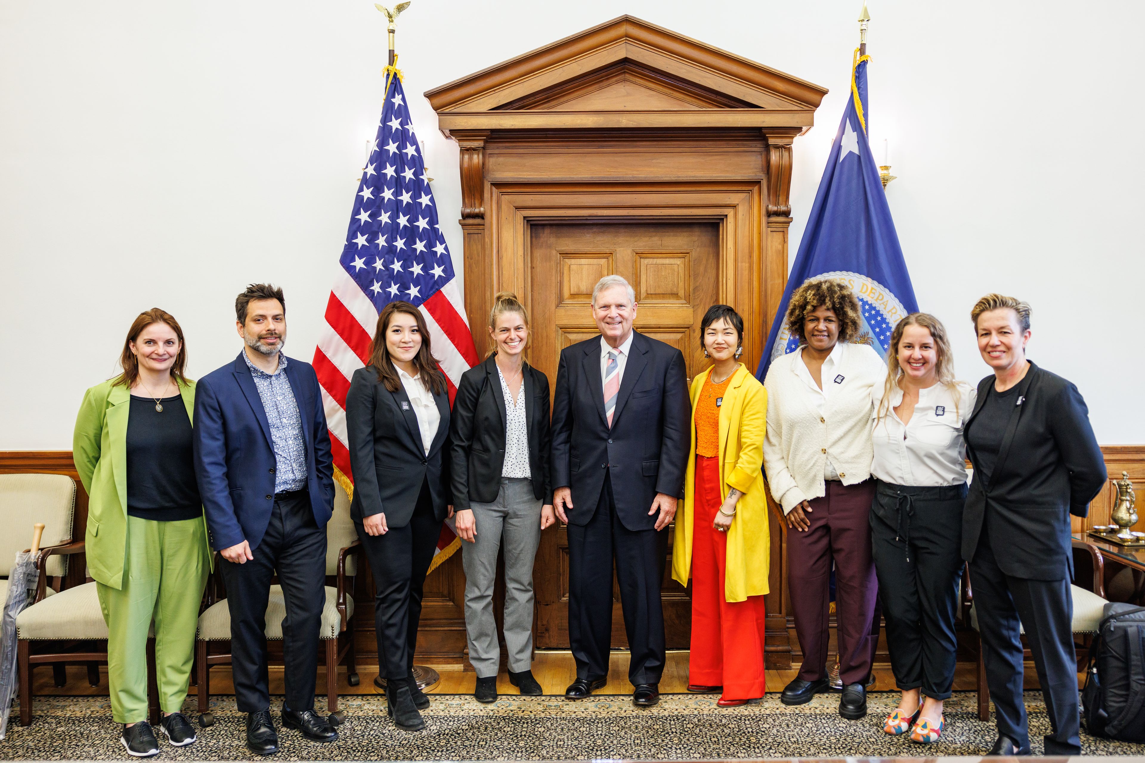 Group in front of U.S. flag and D.C. flag