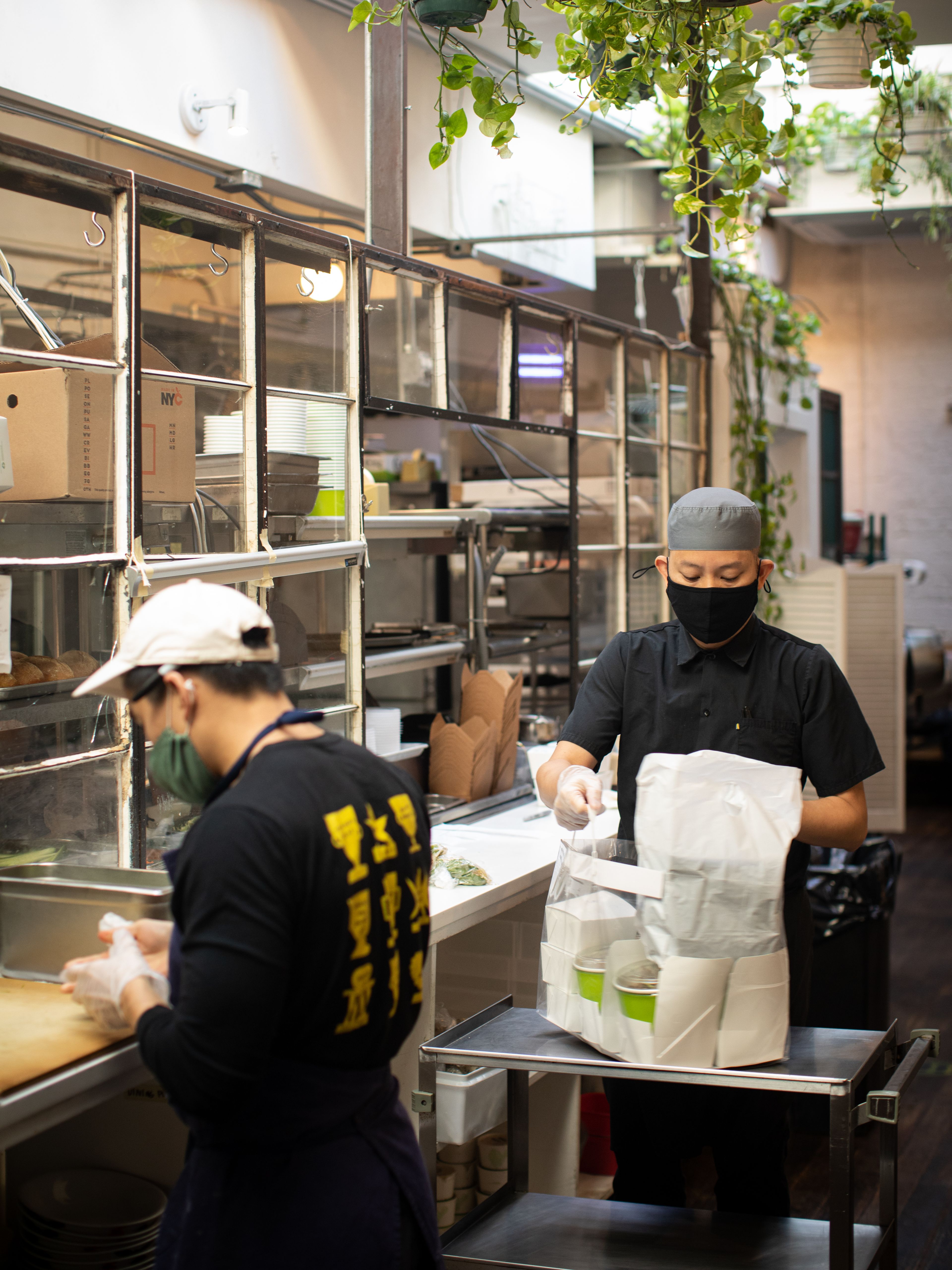 People in masks putting together takeout orders