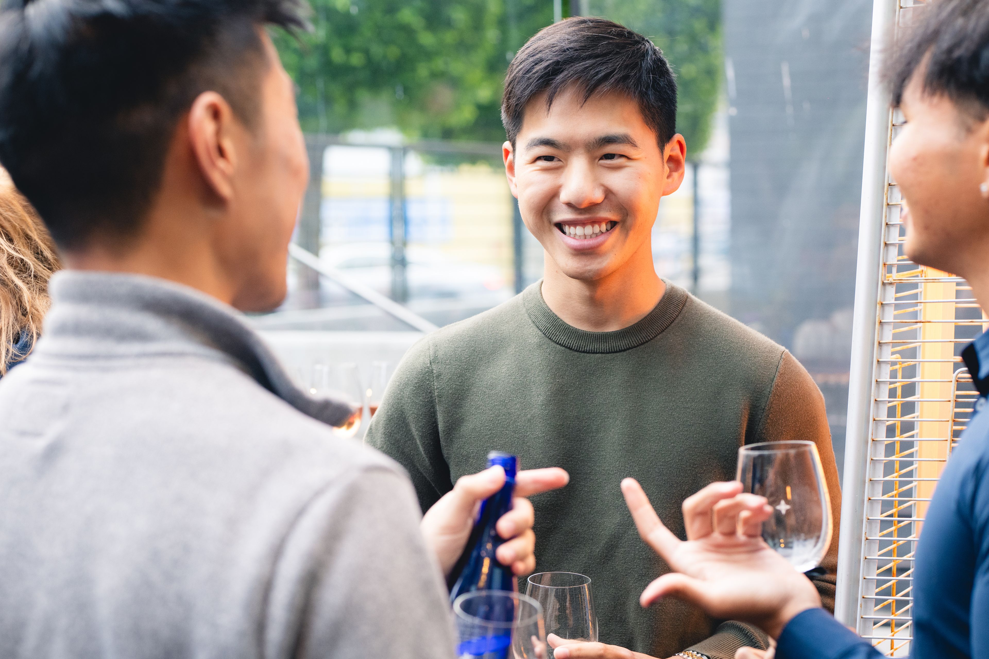 Three men talking and drinking wine