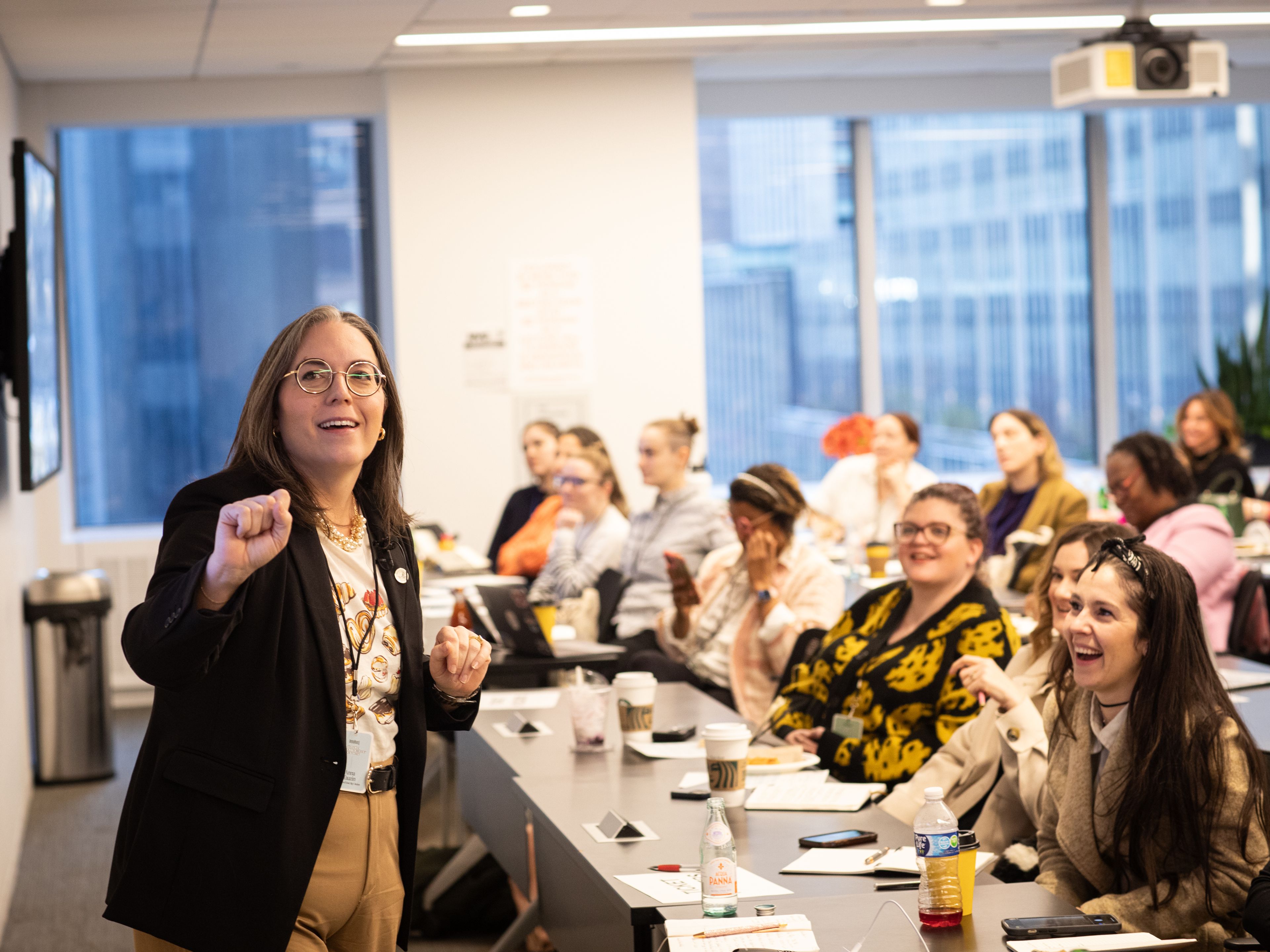 Women presenting to a group of people at tables