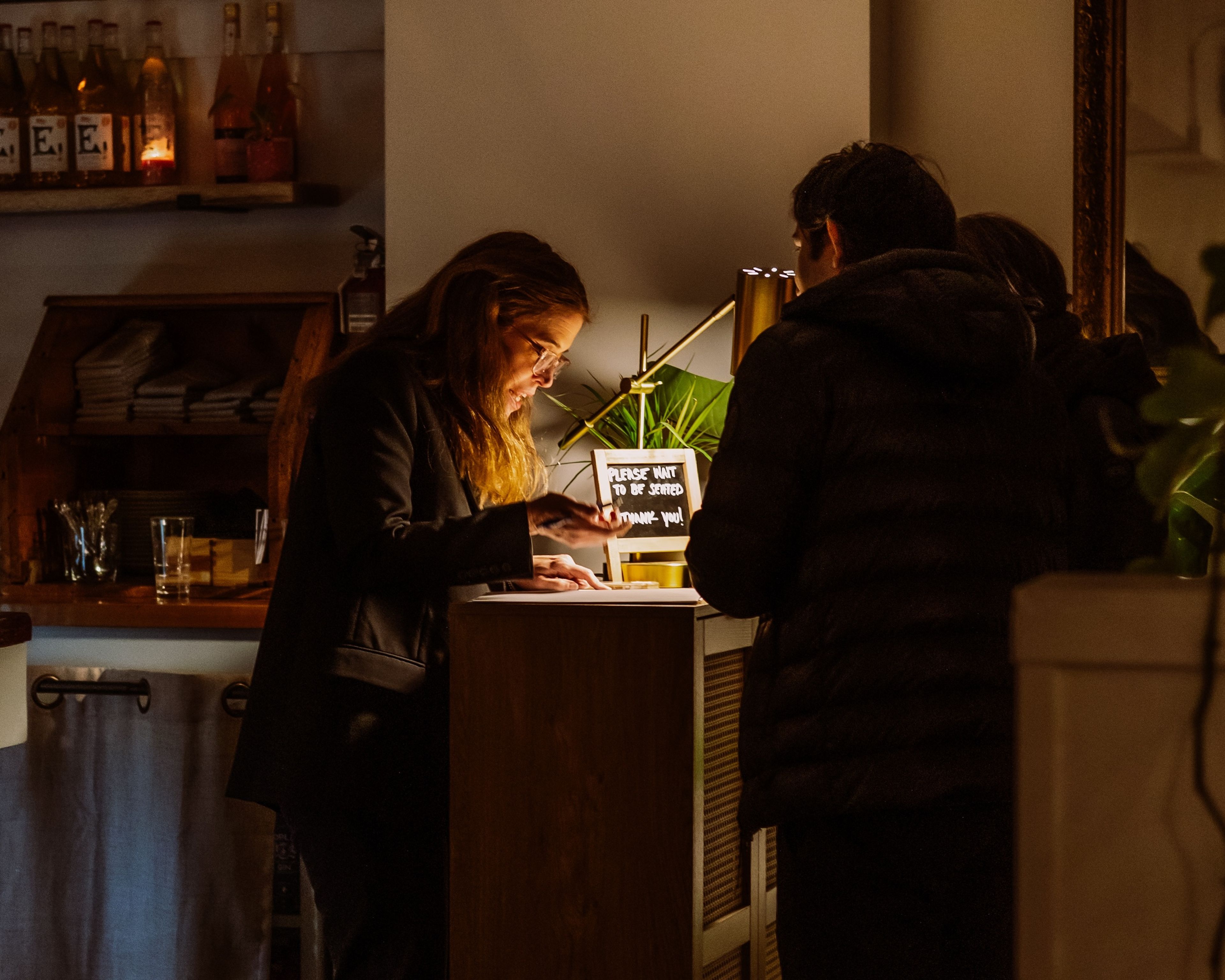 A hostess checks guests in at a restaurant
