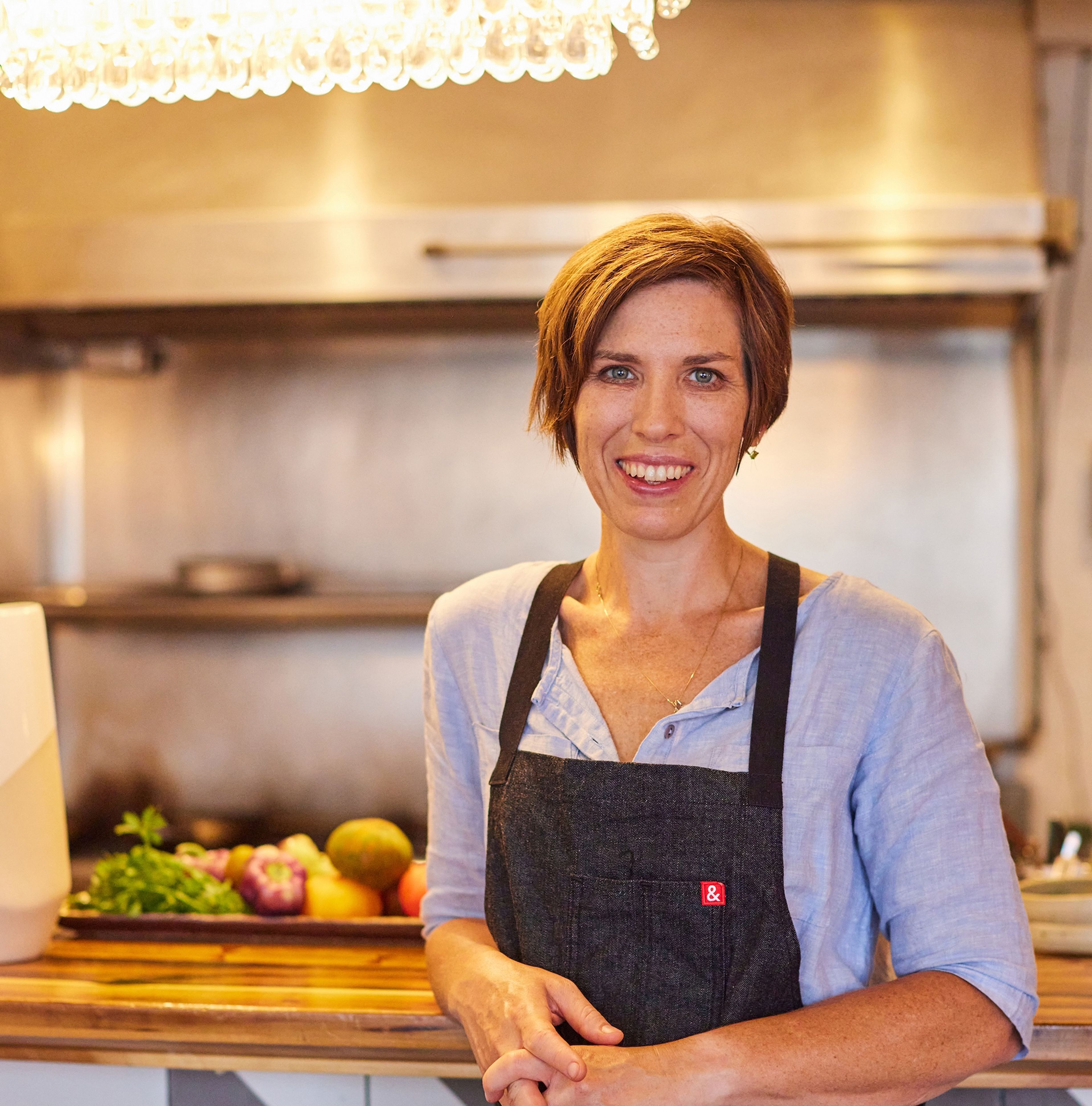 Erin Miller in a casual chef apron at a kitchen counter