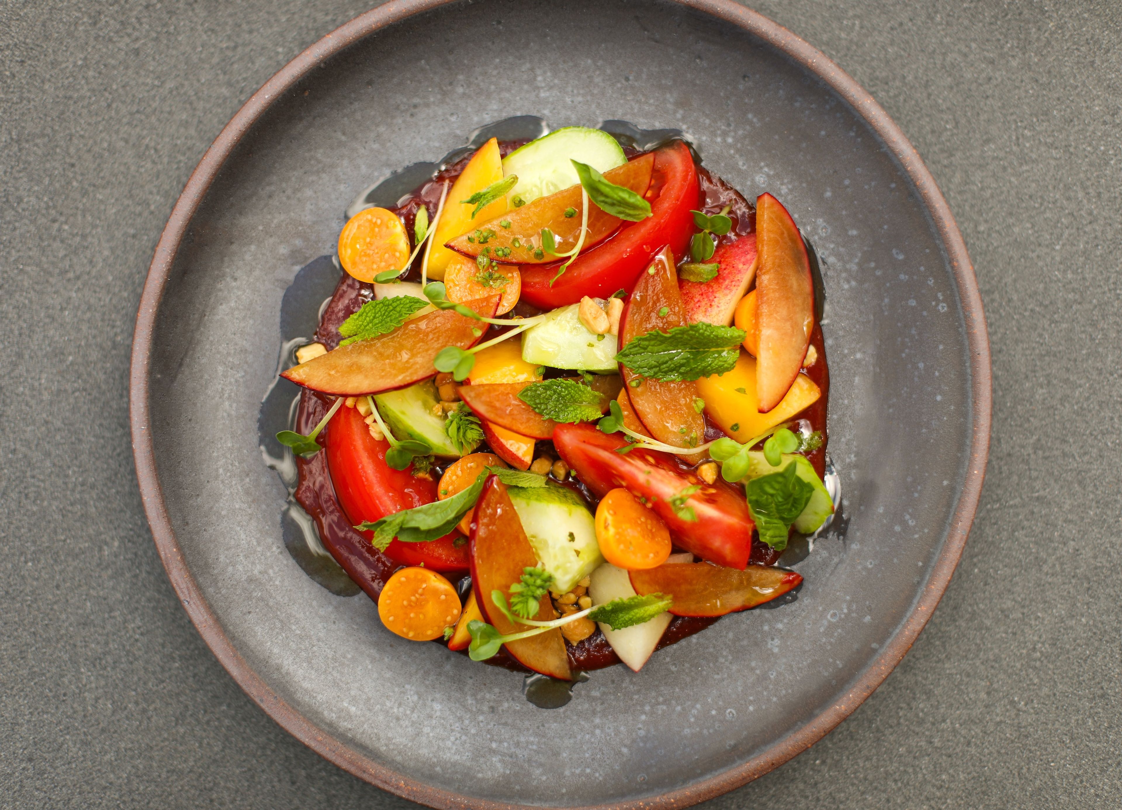A plate of assorted fruits vegetables elegantly presented