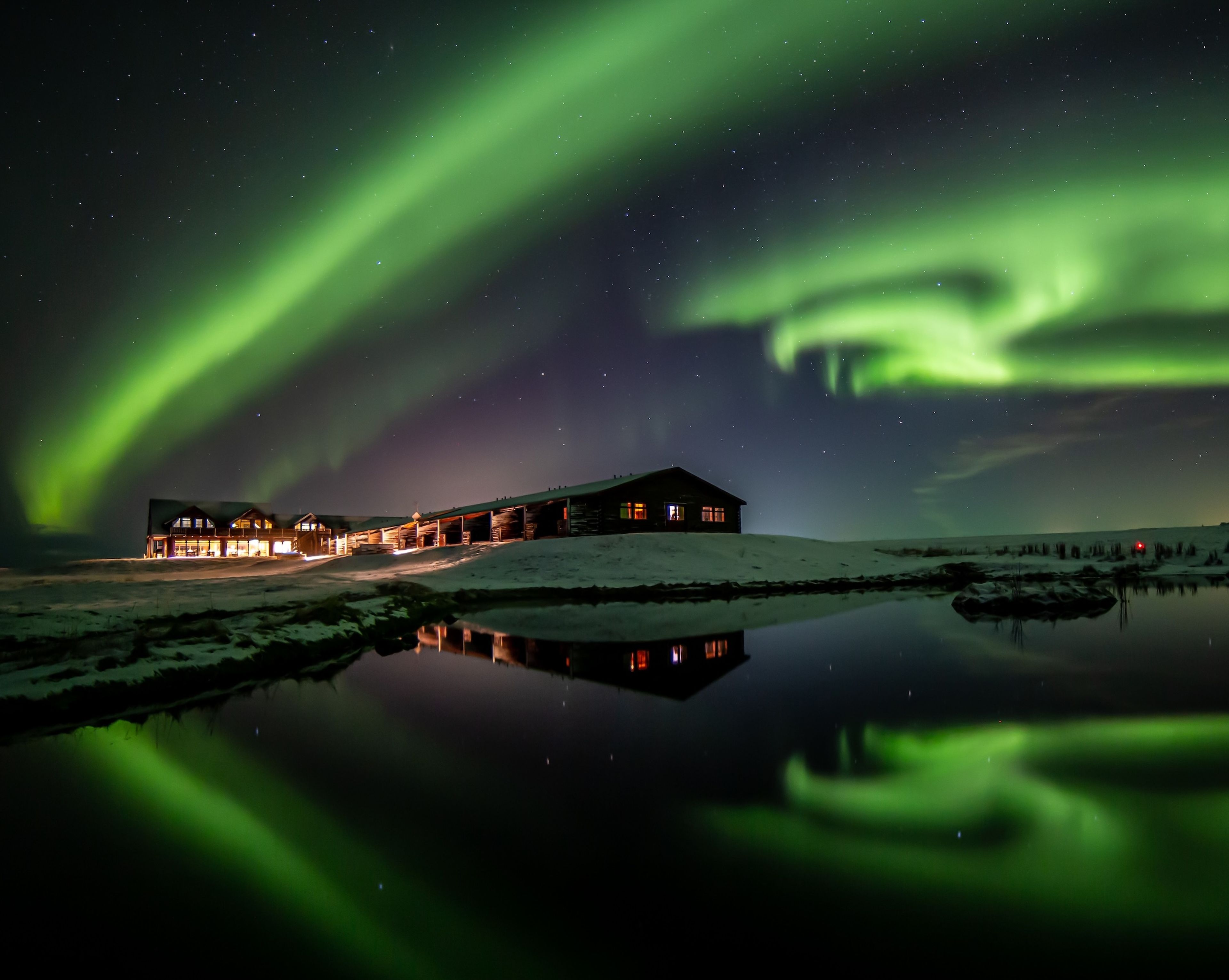 Wide Northern Lights display with a hotel