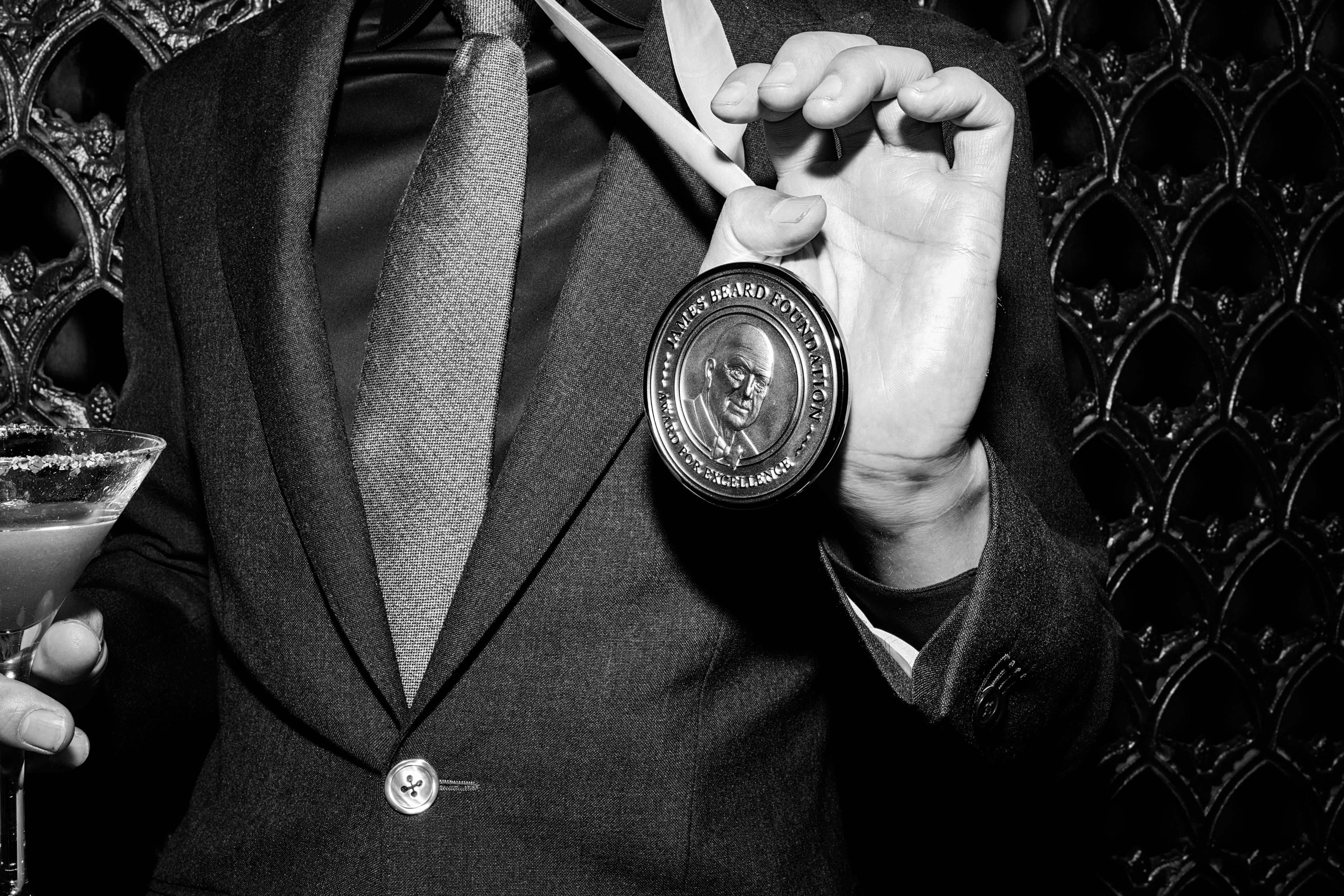 Black and white image of man holding his James Beard Award