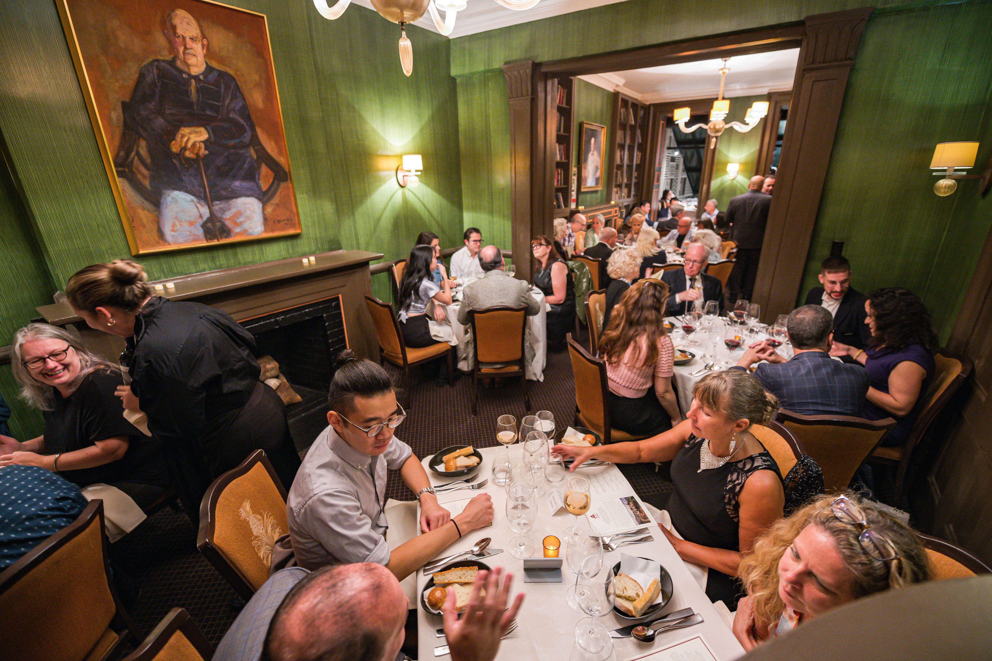 People at different size tables in the Beard House dining room