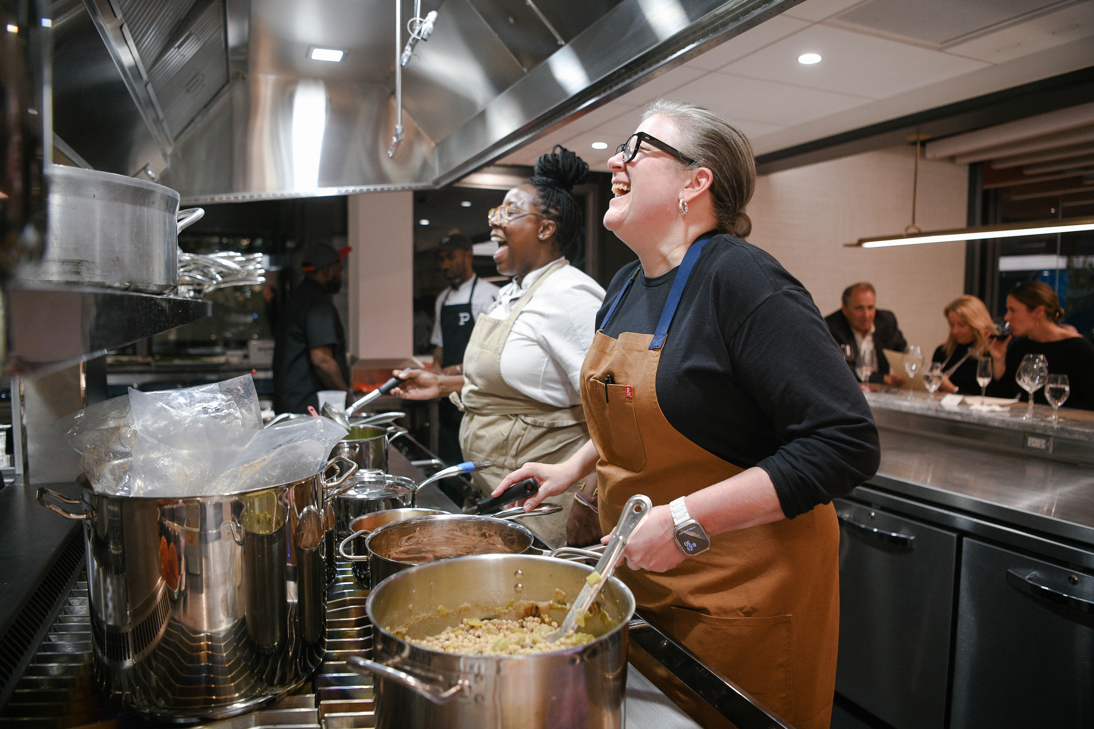 Chefs laughing in the kitchen while cooking