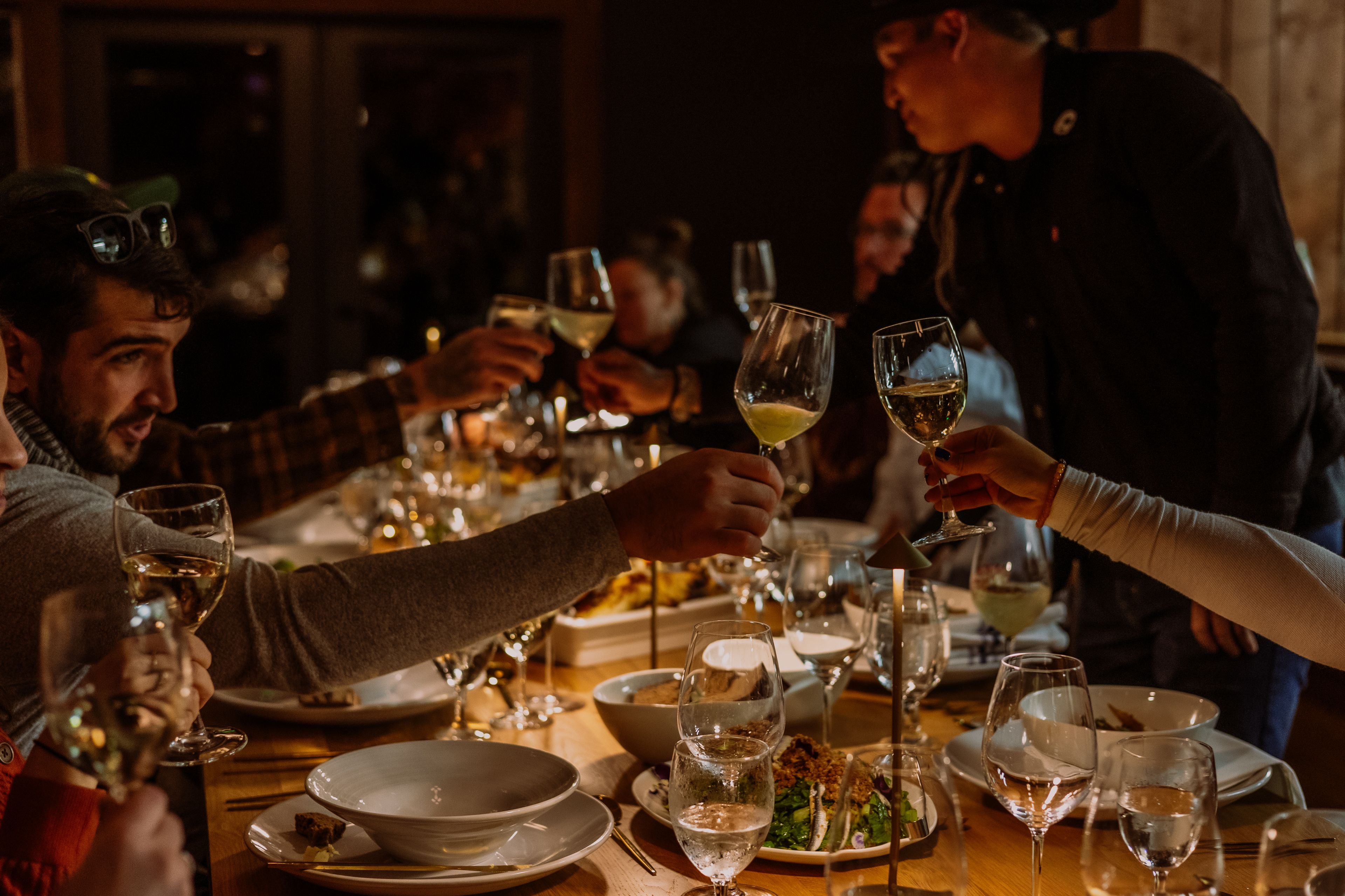 People at a table clinking wine glasses