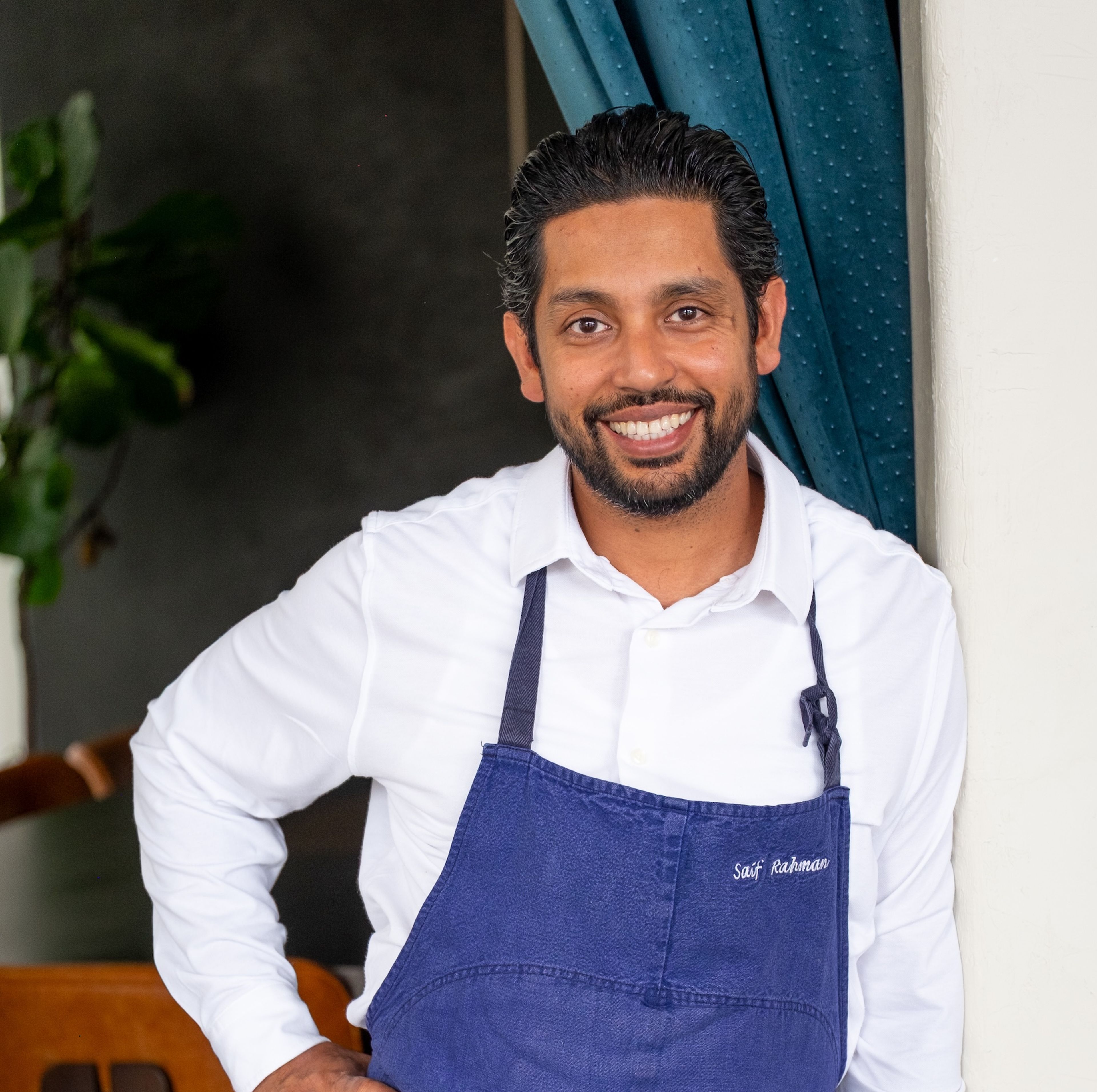 SZaif Rahman in a blue, name-branded apron