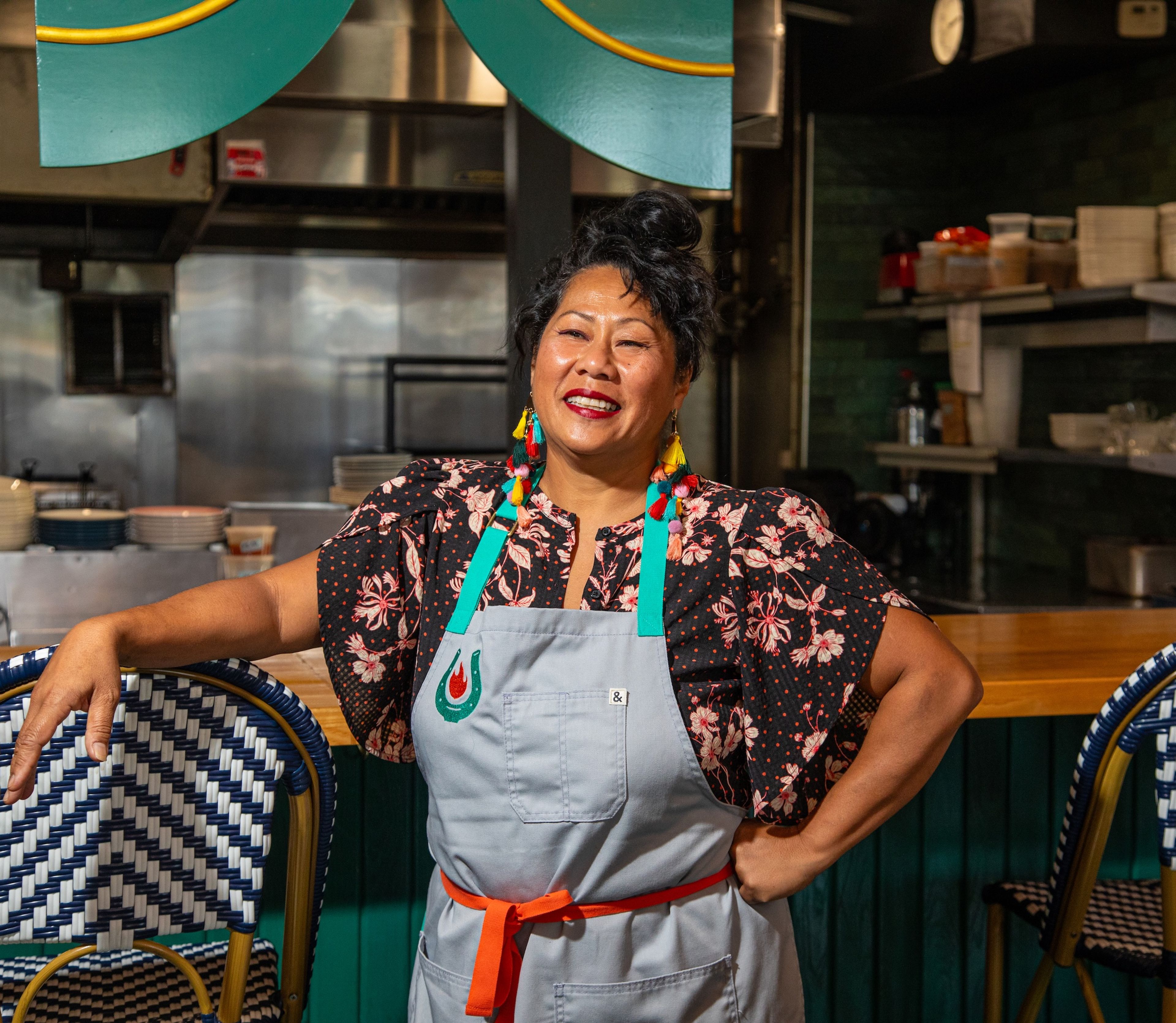 Sophina Uong smiling in front of a restaurant kitchen